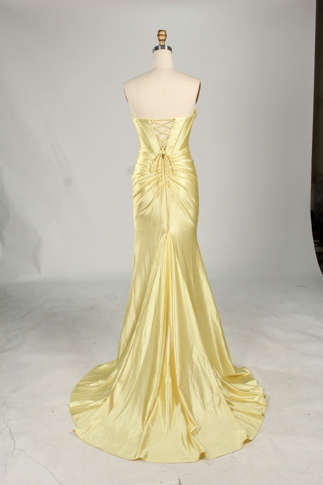 Elegant yellow satin mermaid formal dress with a corset back and train, perfect for proms and formal events. Designer fashion.