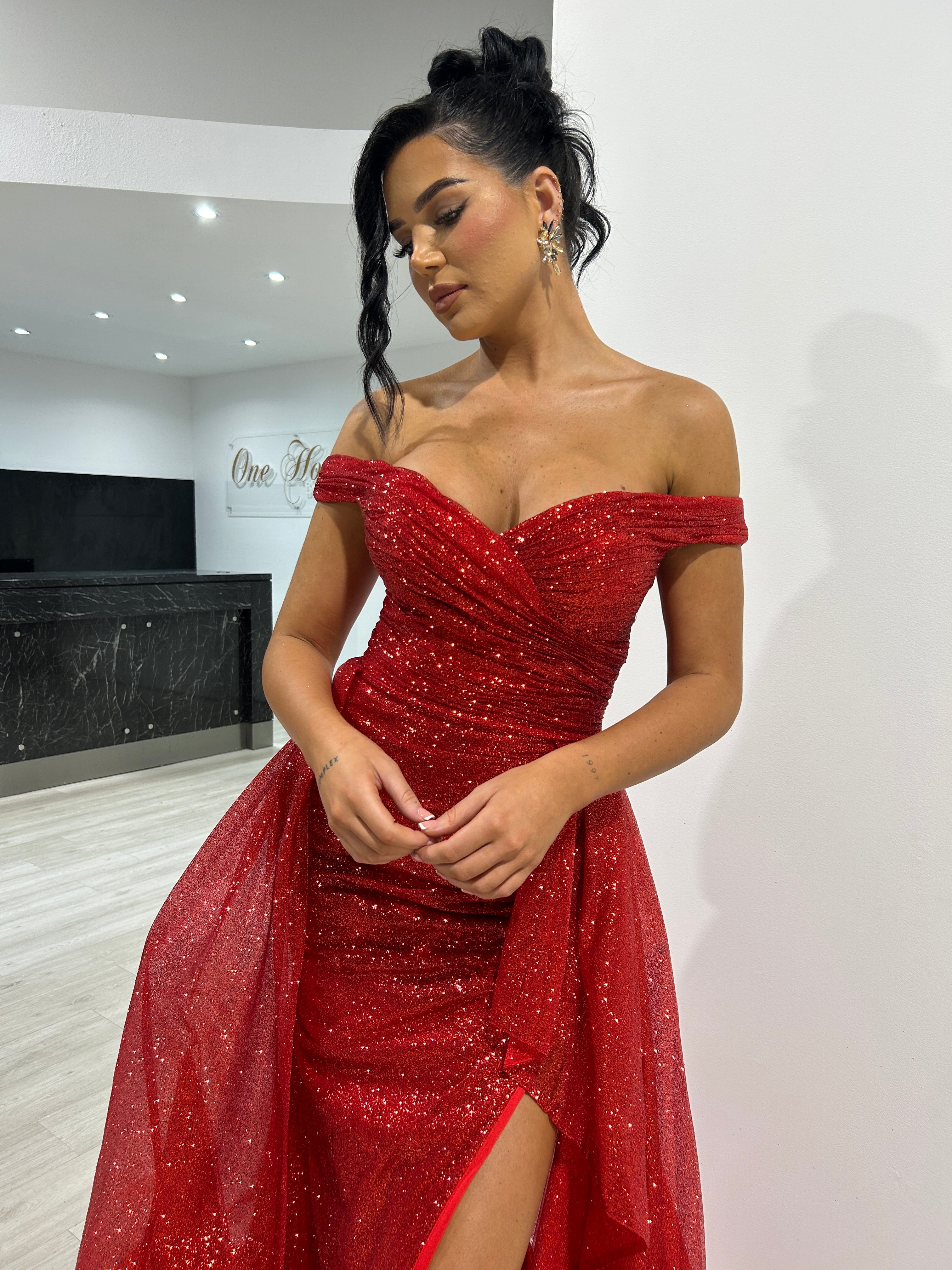 BEBE Glitter red off-the-shoulder overskirt evening gown with shimmering fabric. Perfect for nights out from Brisbane to Gold Coast.