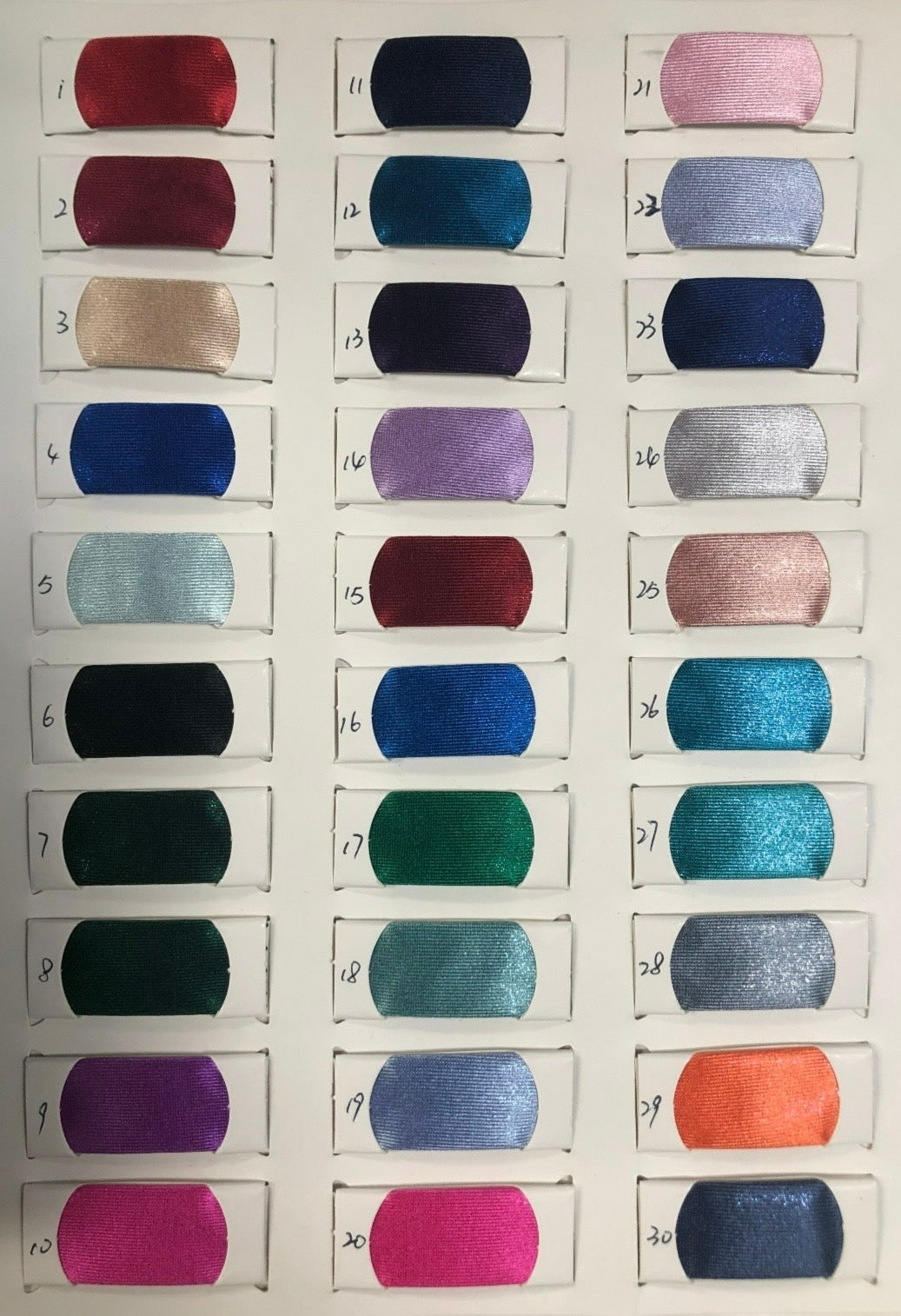 Color swatches in various shades of satin fabric used for formal dresses.