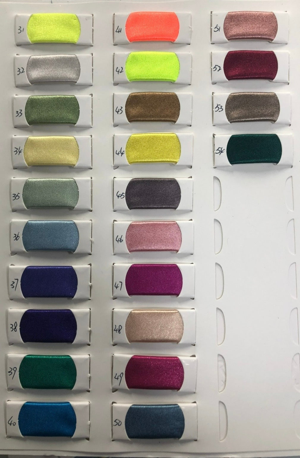 Color swatch card featuring 24 fabric samples, each labeled with numbers, showcasing a variety of vibrant and neutral tones.