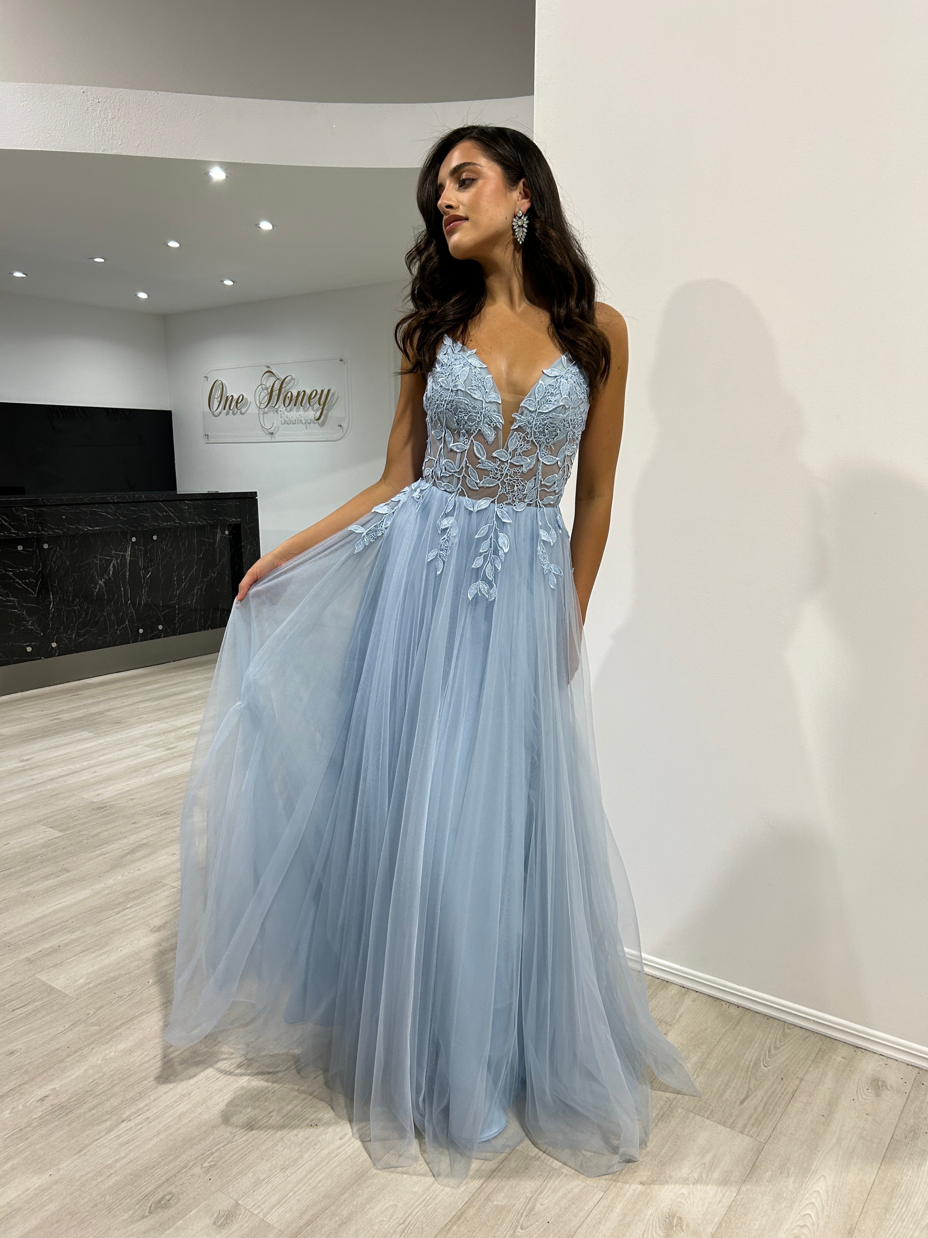 Model wearing Honey Couture JARRISSA Blue Tulle A Line Formal Dress; an Australian Designer prom gown with lace applique and corset back.