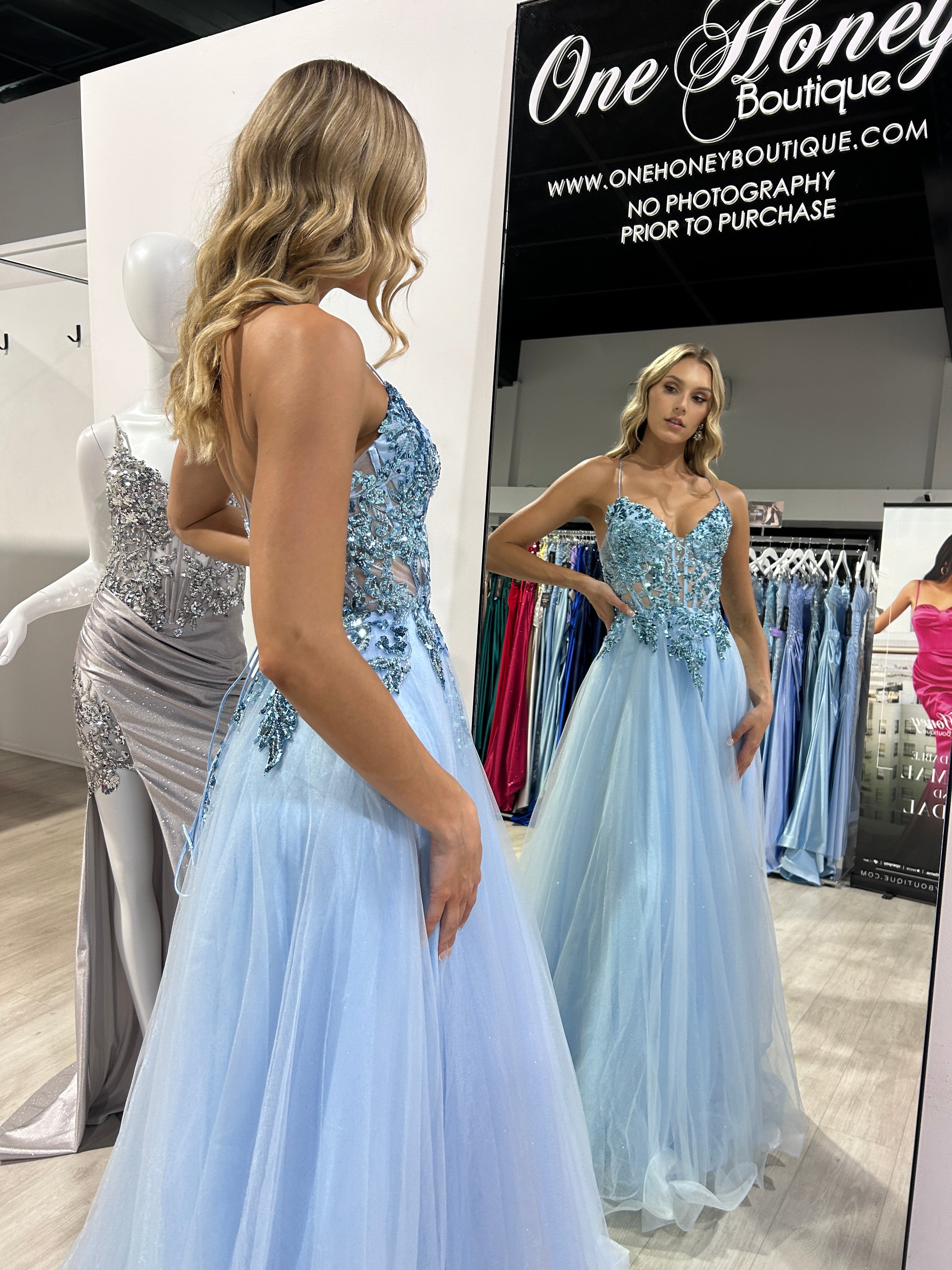Blonde woman in blue Honey Couture NOVINE sequin & glitter mesh tulle formal dress, mirror reflection, Australian formal store display.