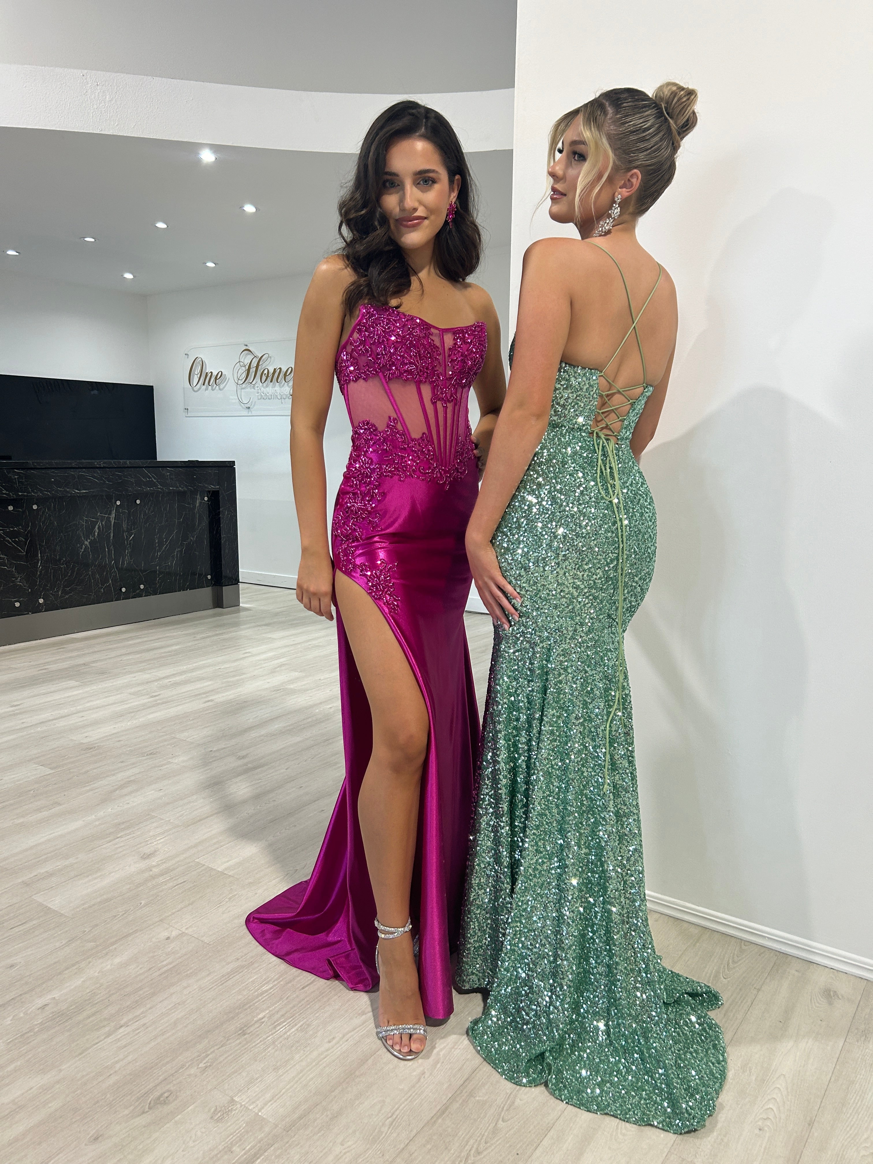 Elegant strapless magenta gown with lace bodice and thigh-high slit, alongside a glittering green backless formal dress. Brisbane to Gold Coast.