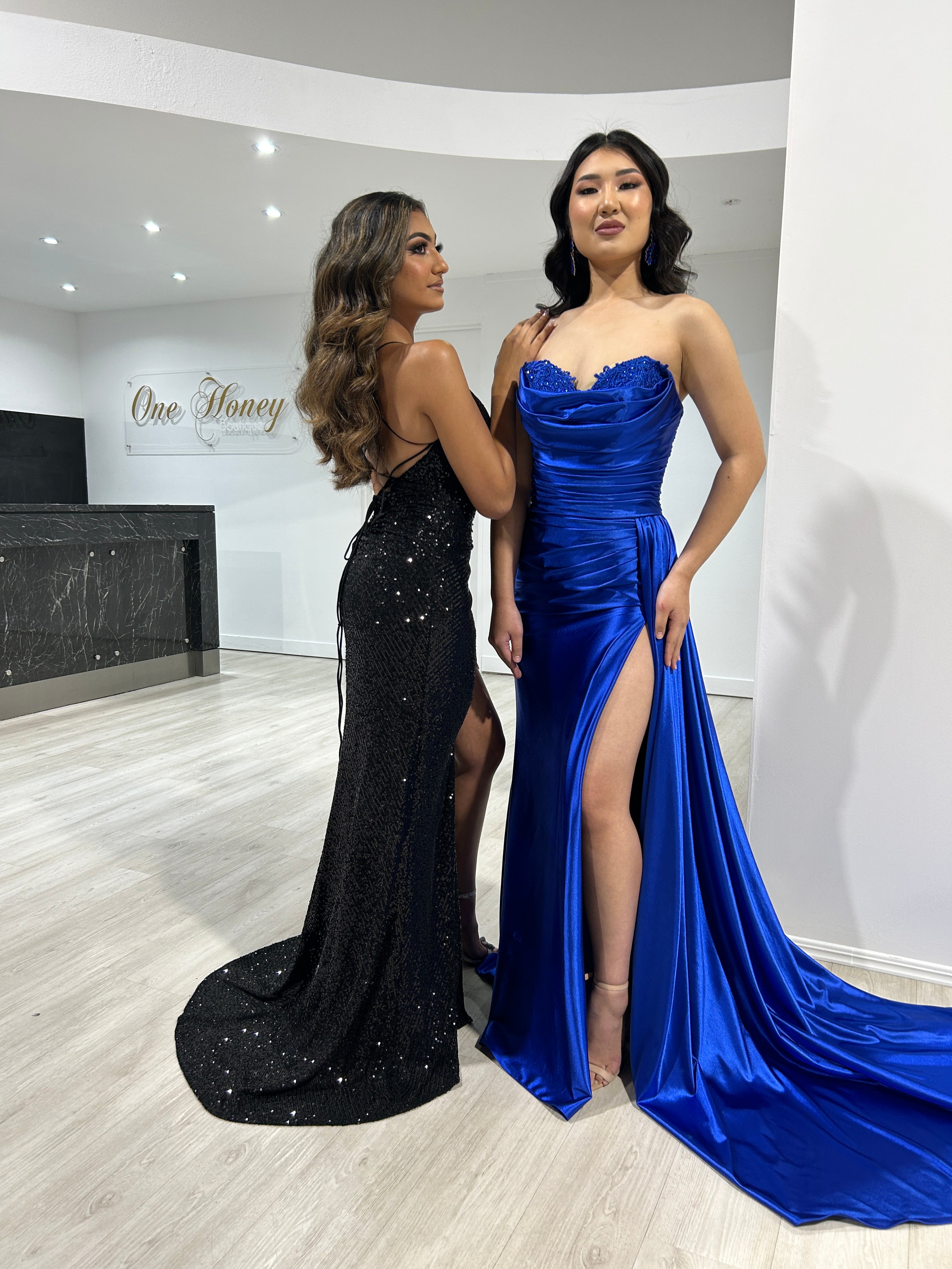 Royal Blue Sherri Hill 55230 strapless mermaid prom dress with diamante detail next to black sequin gown indoors