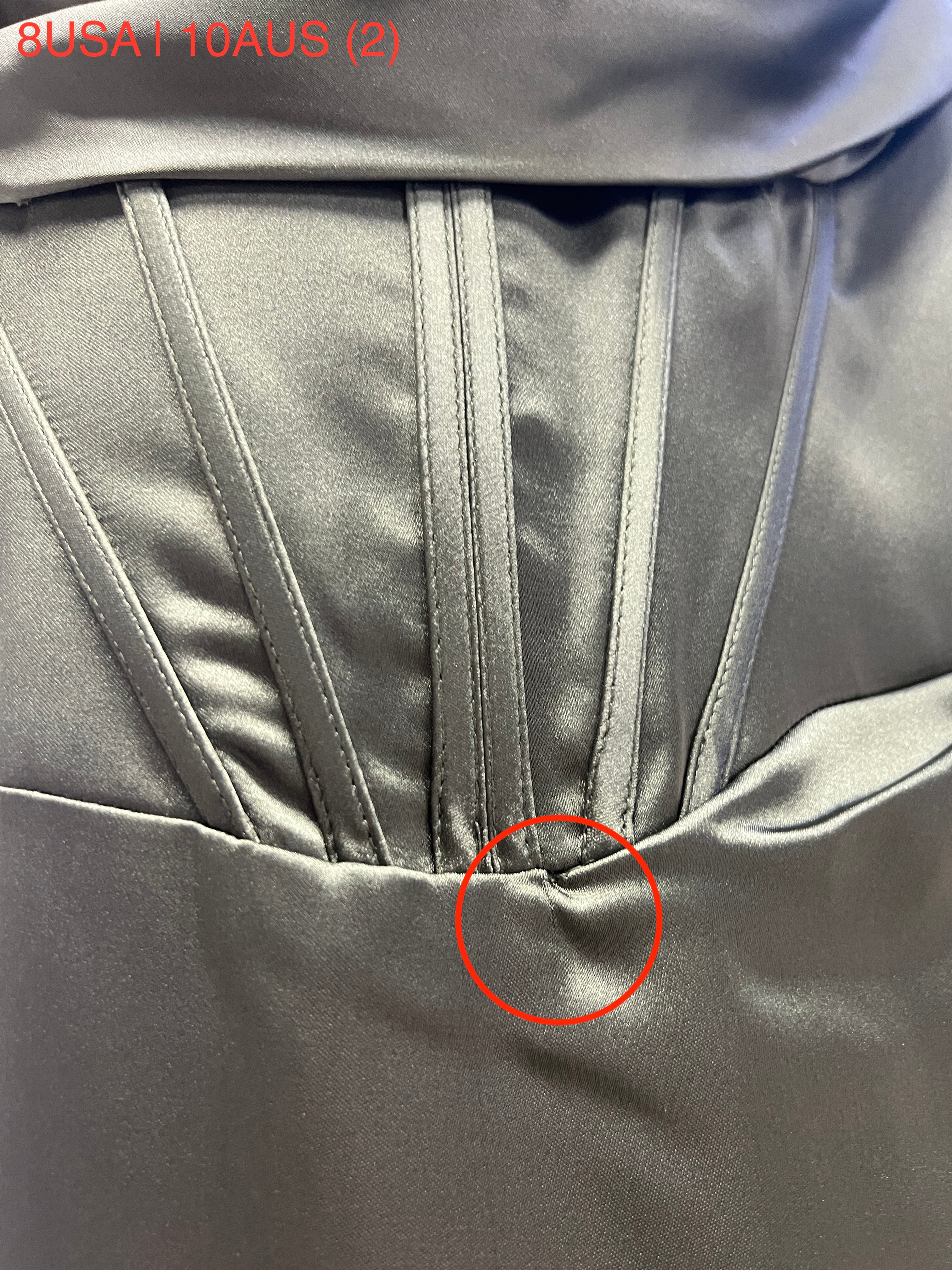 Close-up of Honey Couture dress fabric showing stitching detail, highlighting satin material and corset structure.
