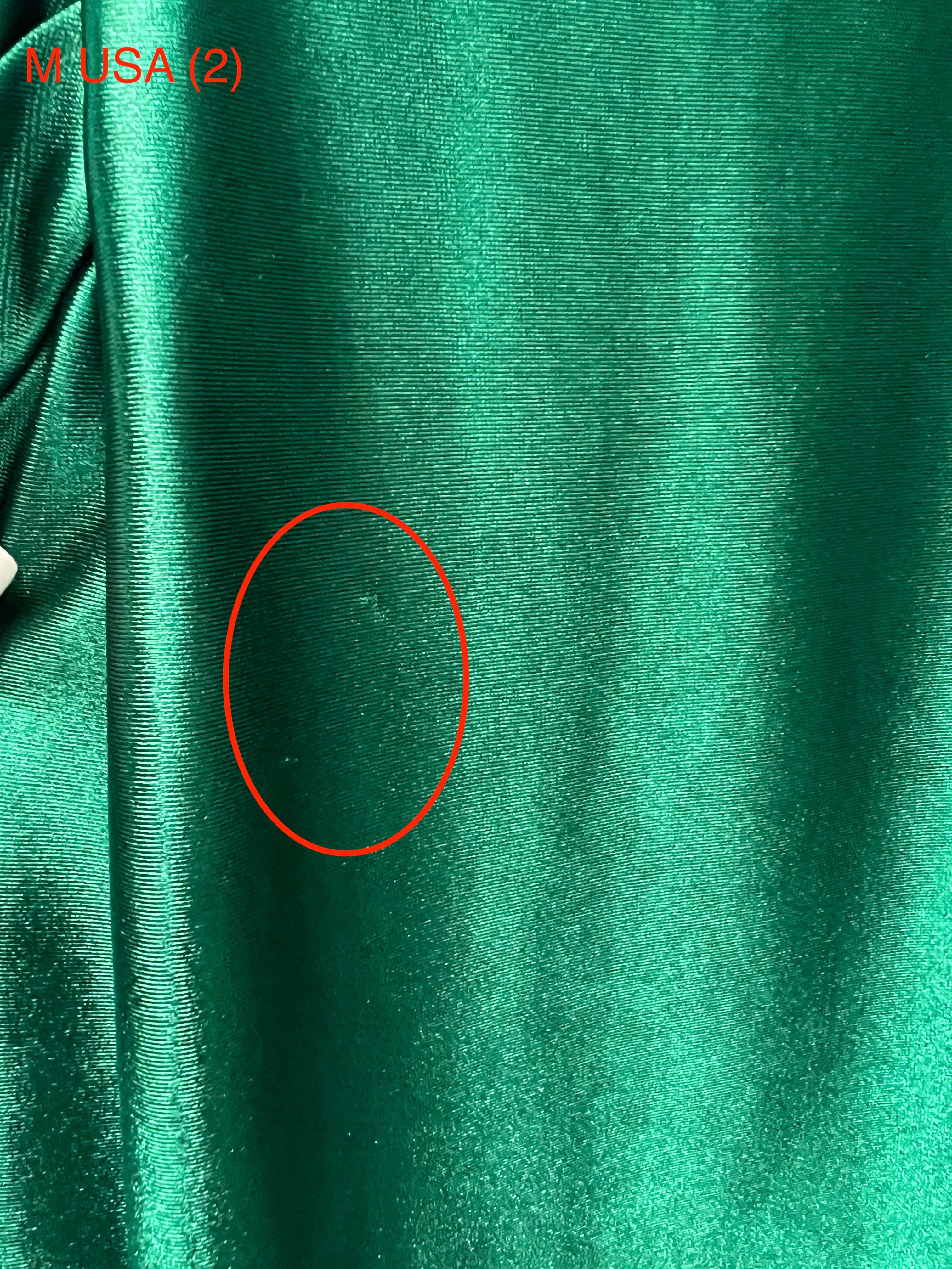 Close-up of the Honey Couture SHARYN Emerald Green silky fabric detail, highlighting texture. Ideal for affordable evening gowns and prom dresses.