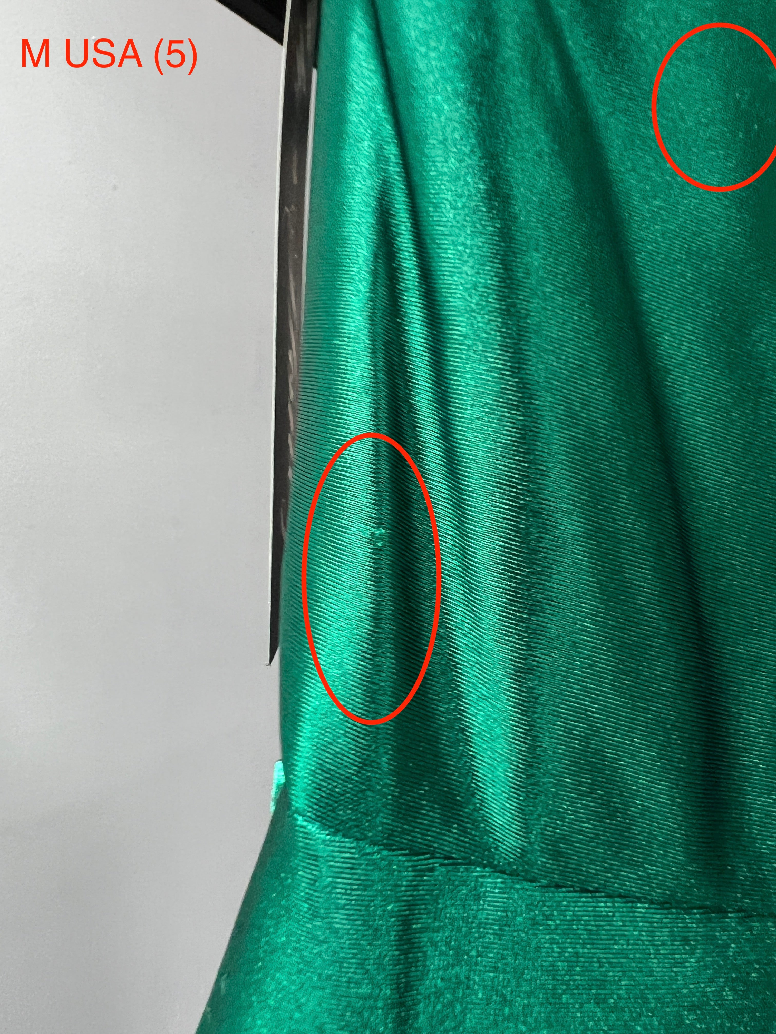 Close-up of the SHARYN Emerald Green silky mermaid dress showing fabric details and imperfections, by Honey Couture.