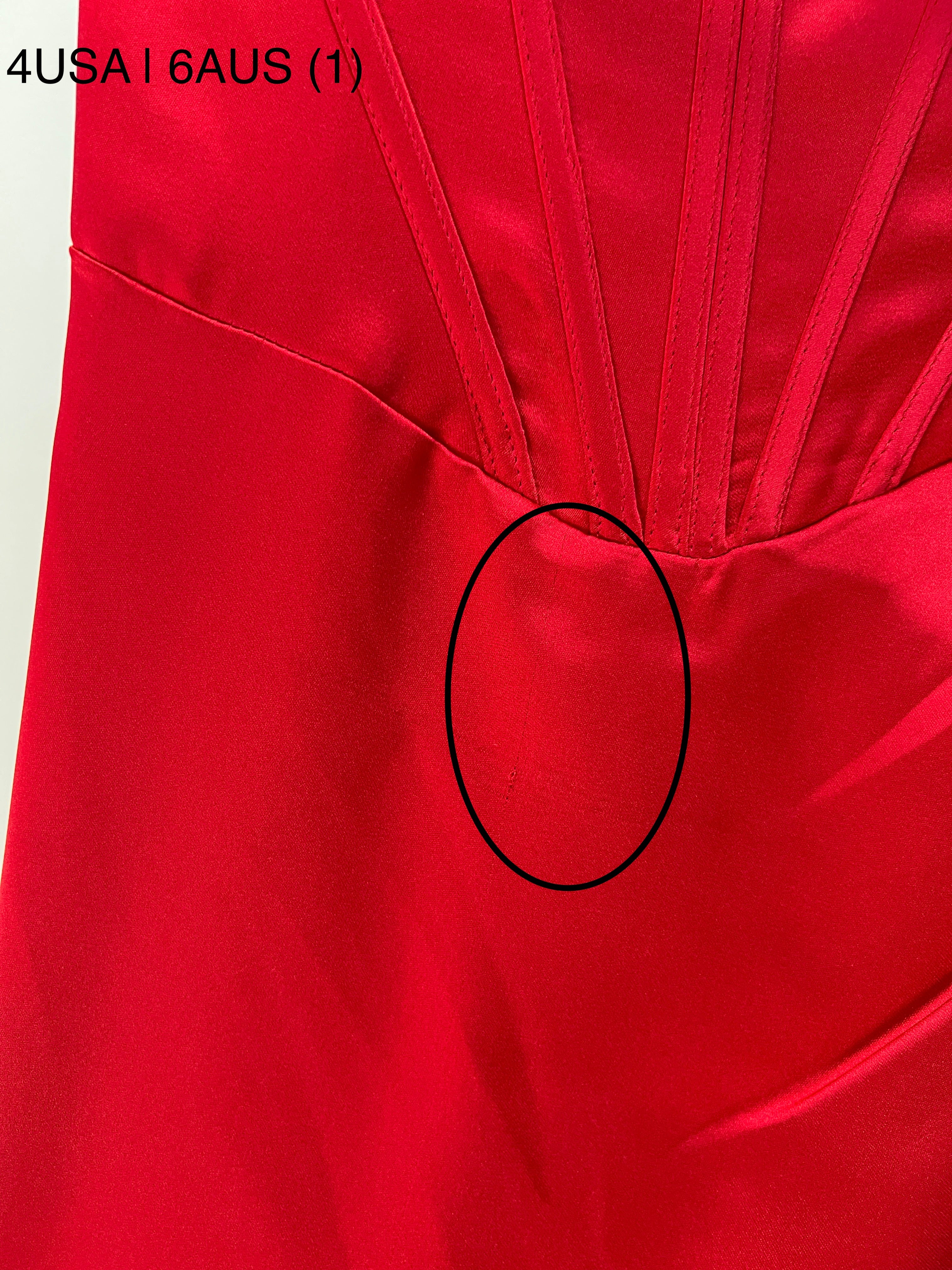Close-up of Honey Couture ZENDAYA red satin dress with visible flaw, highlighting material and stitching details for buyer awareness.