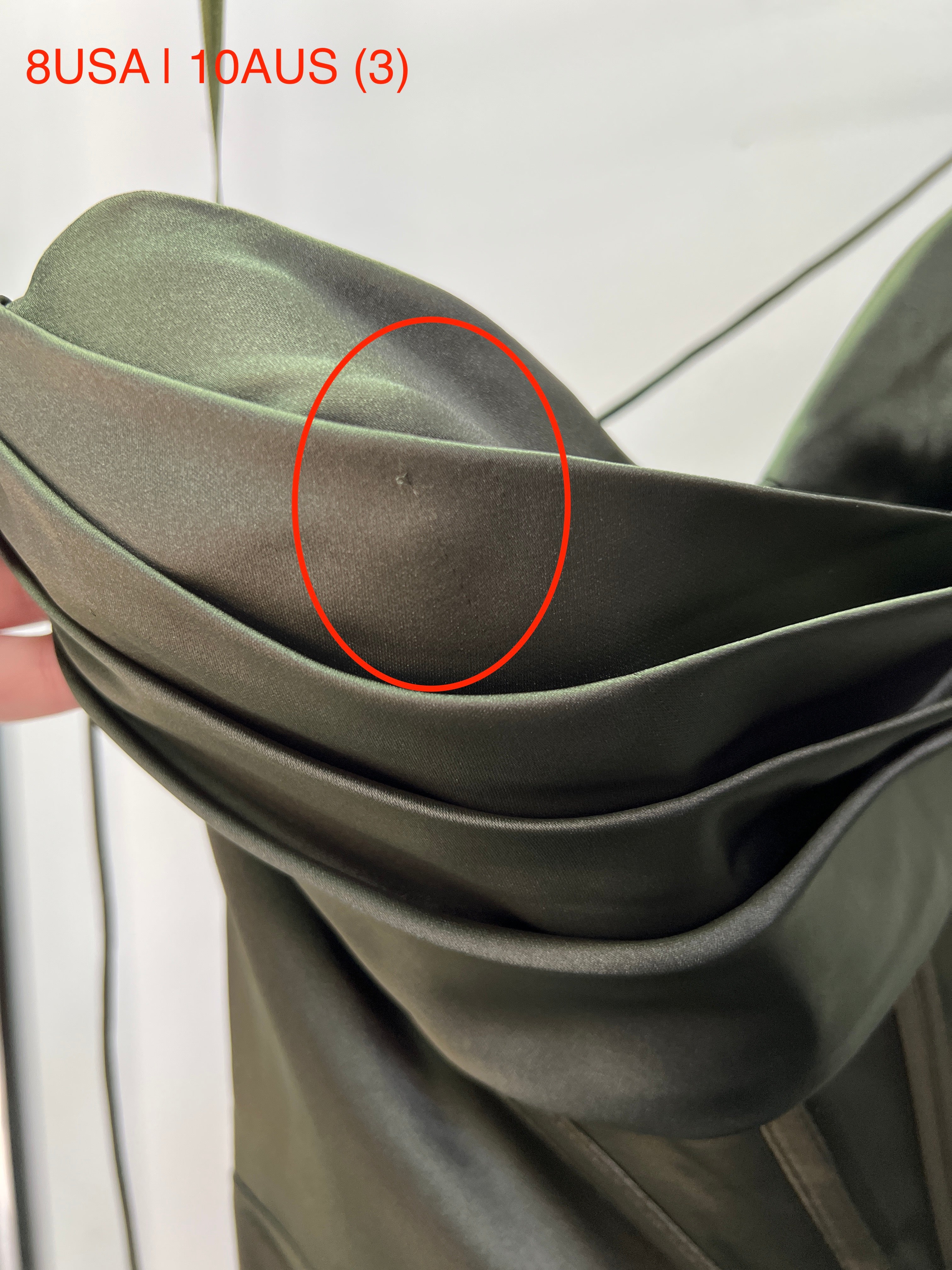 Close-up of the Honey Couture ZENDAYA Olive Green Satin Corset Bustier fabric with seam detail, size 10AUS, showcasing elegant draping.