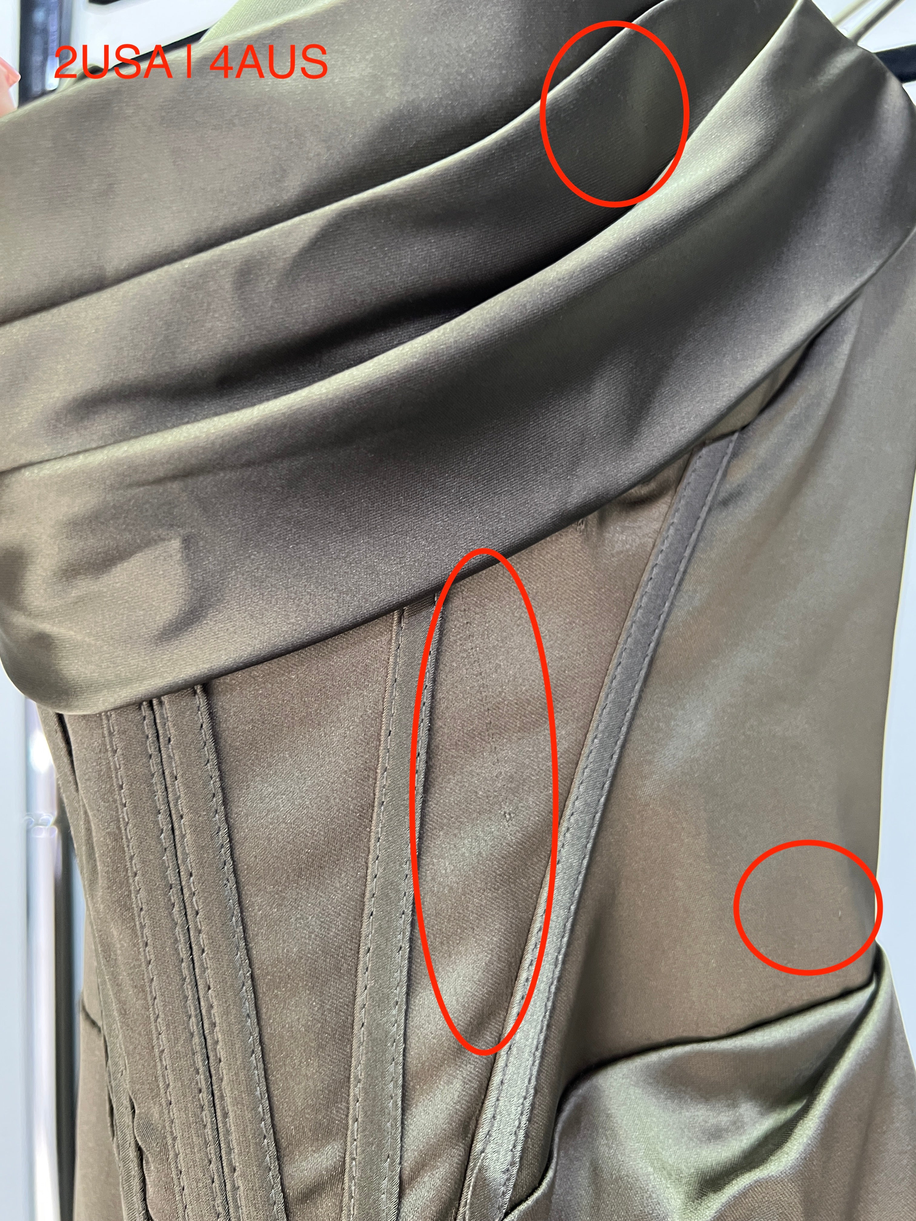 Close-up of Honey Couture ZENDAYA olive green satin corset bustier dress, showing silky fabric and lace-up detail. Limited edition.