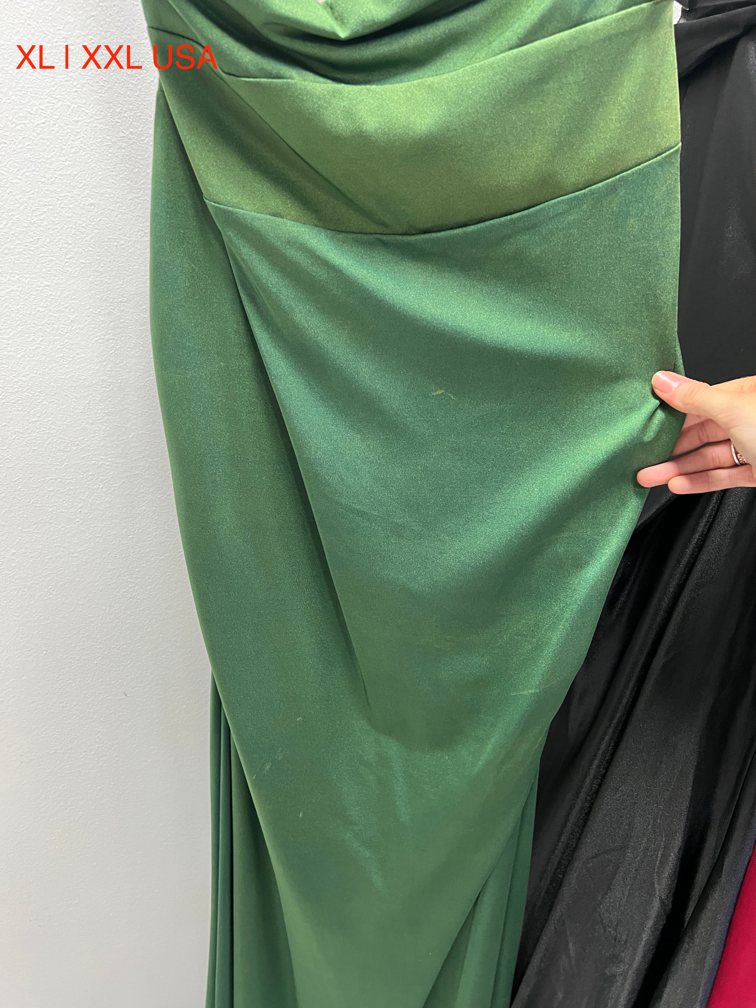 Close-up of Honey Couture STACY Emerald Green mermaid formal dress fabric with a hand showing the ruched detail.