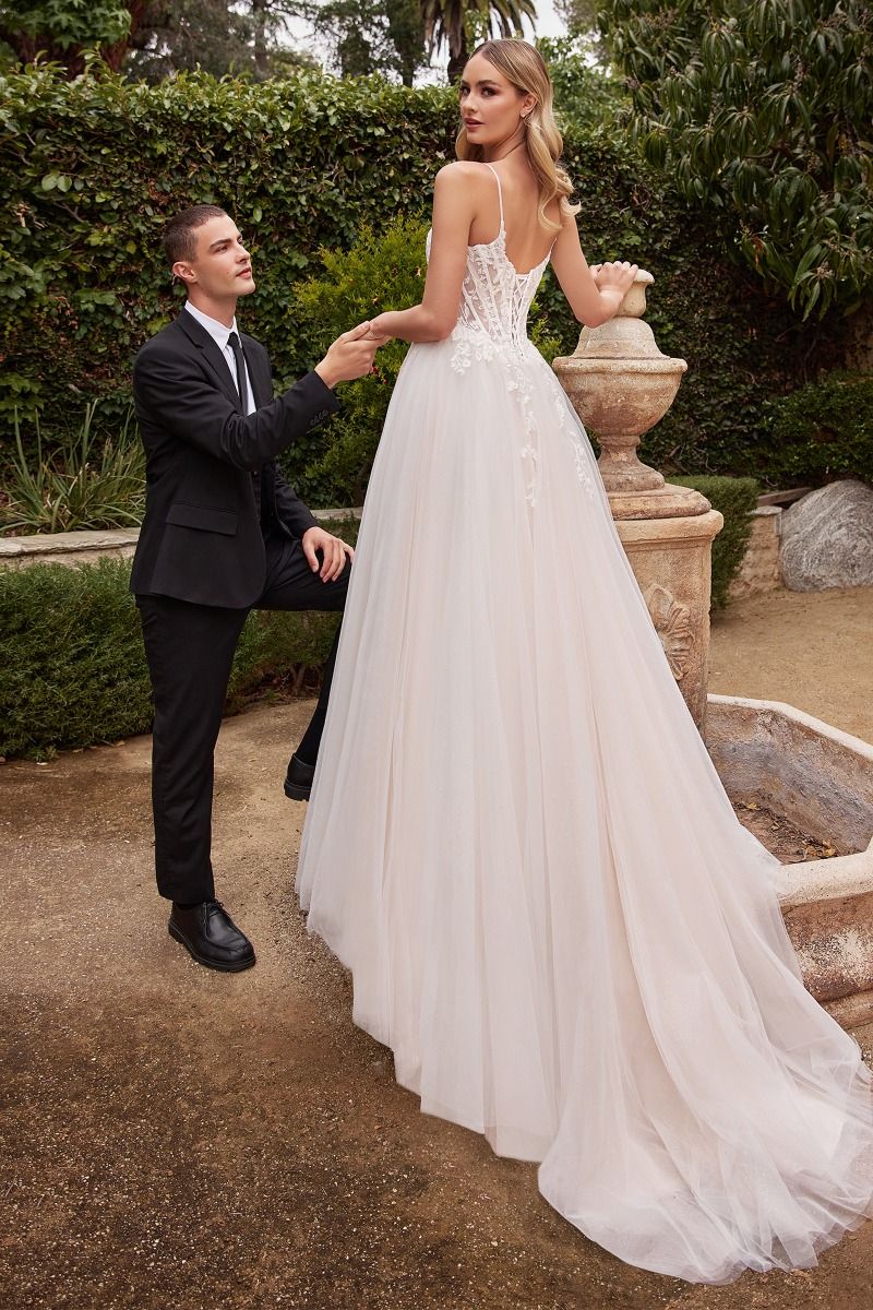 Woman in Divinity Bridal ROSALIND A Line Tulle Wedding Dress with lace bodice, an affordable bridal gown, in a garden setting.