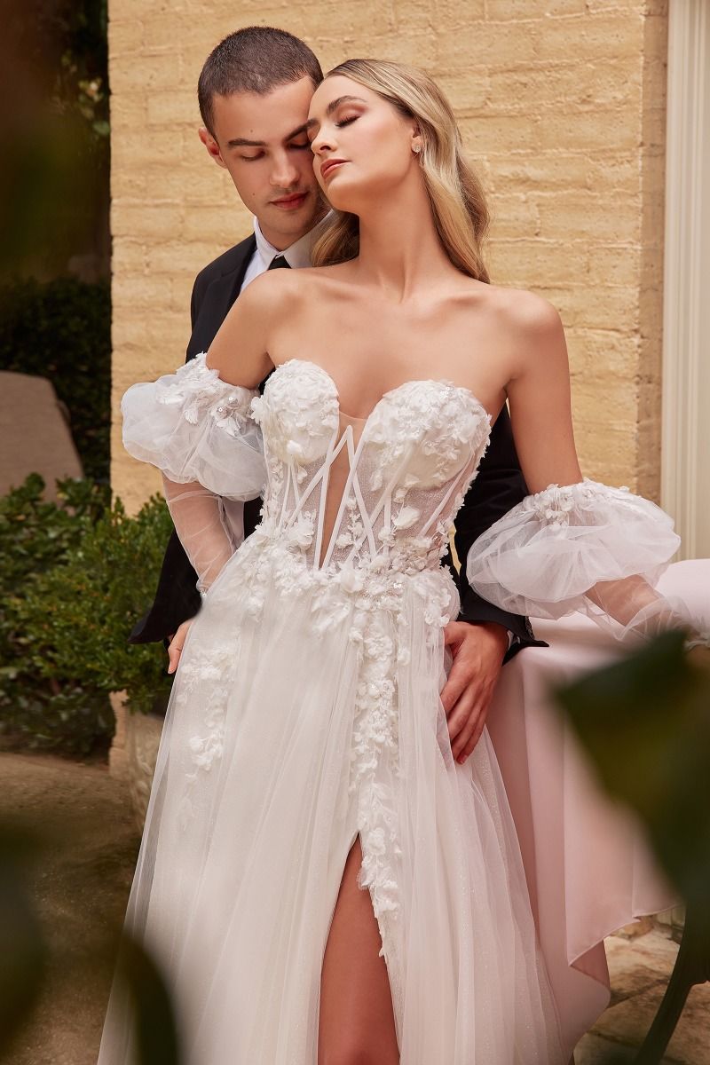 A bride in the ADRIANNA Floral Applique A Line Tulle Corset Wedding Dress, an affordable bridal gown by Divinity Bridal with 3D lace and sheer bodice.