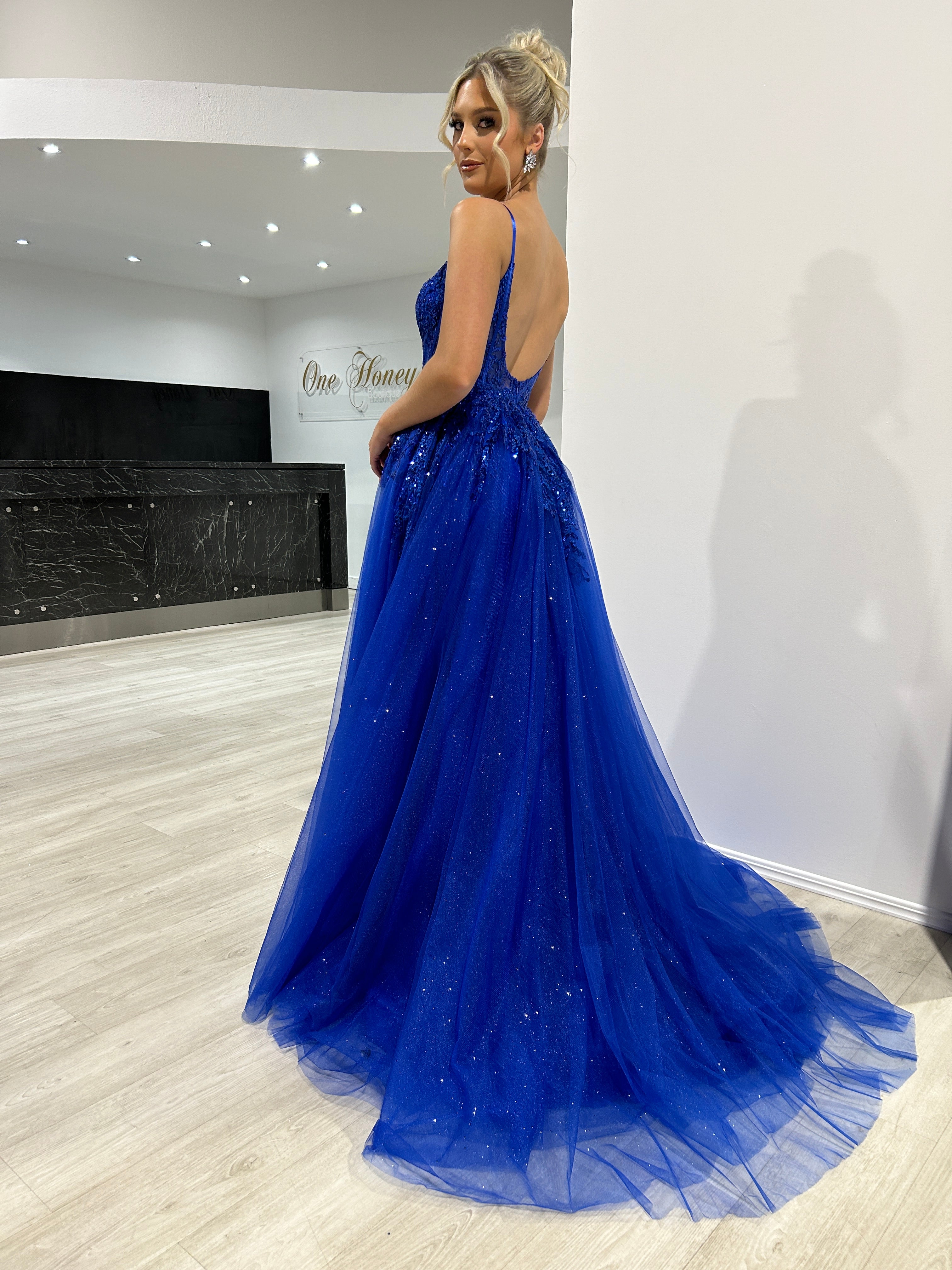 Woman wearing a Honey Couture PANDORA Tulle Bustier Ball Gown, an elegant royal blue formal dress by an Australian designer, perfect for proms.