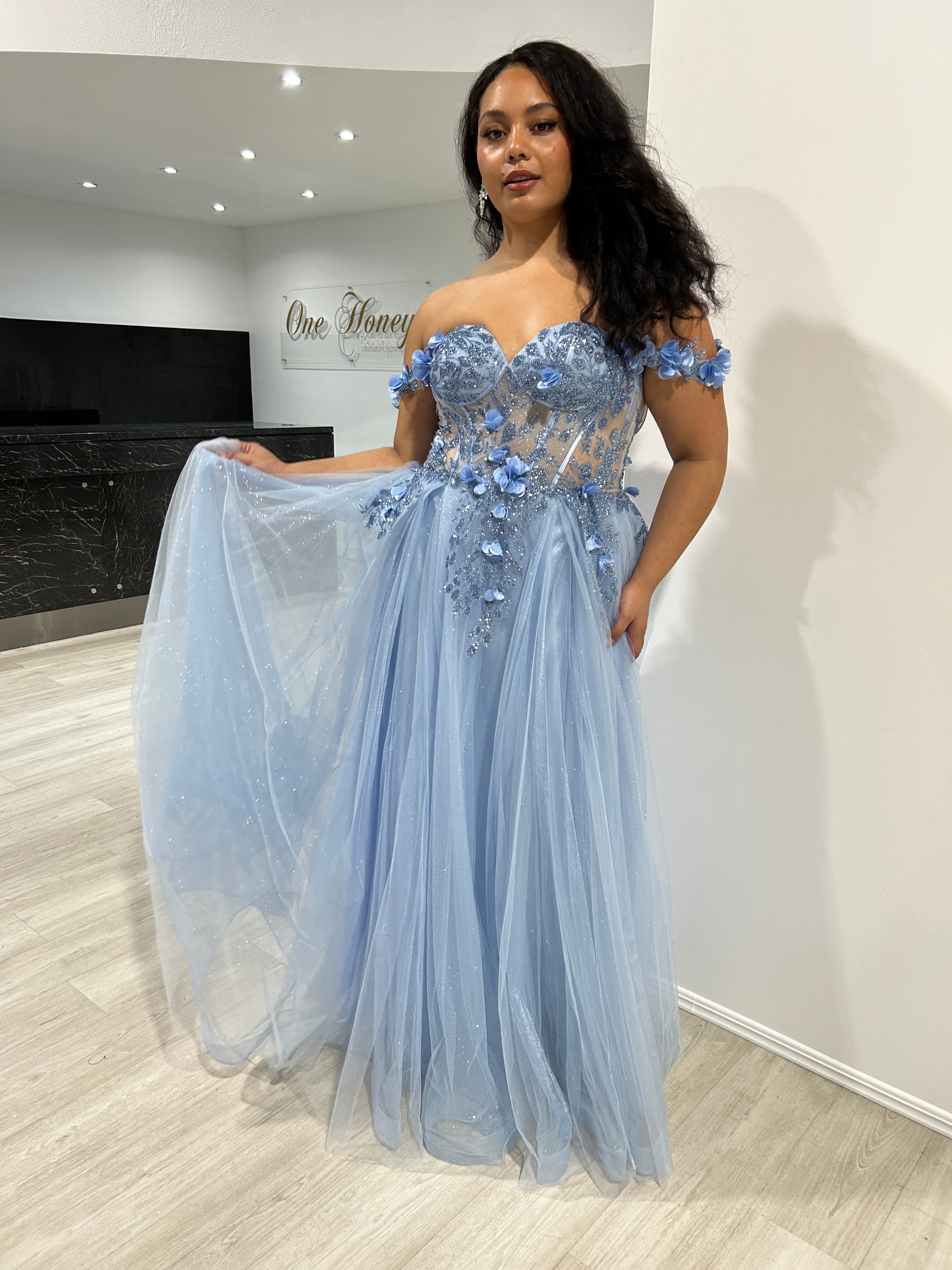 Woman wearing Honey Couture KARRISA blue glitter off-the-shoulder A-line dress, perfect for proms or evening events by an Australian designer.