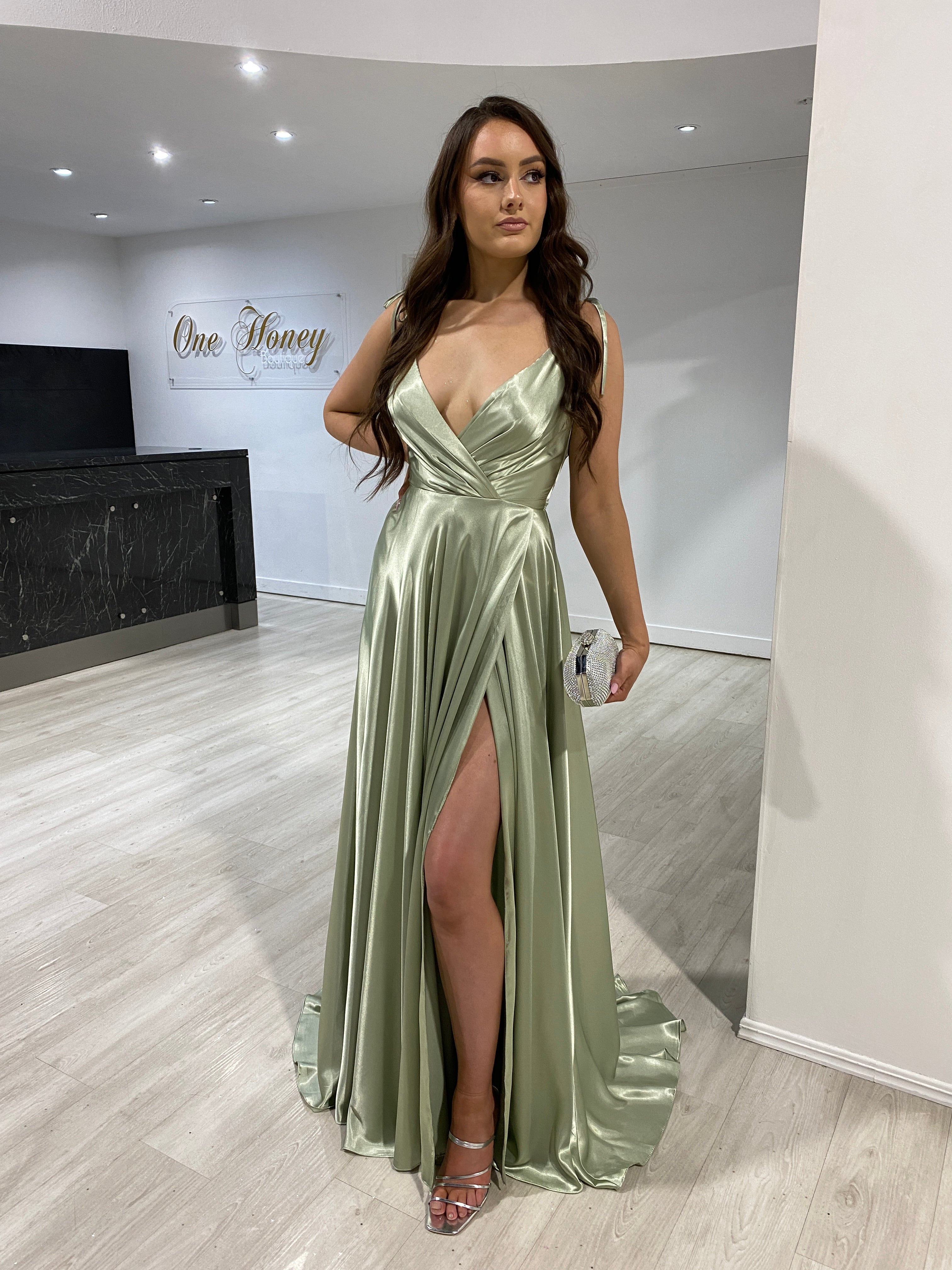 Woman wearing Honey Couture HUNTAR Sage Green Silky A Line Bridesmaid Formal Dress with a leg split by Australian Designer.