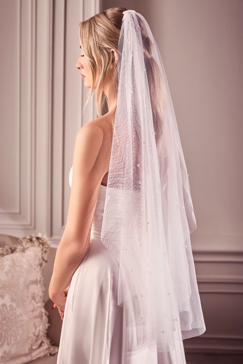 Bridal model wearing CAPRI Pearl Drop Off White Wedding Veil, affordable bridal accessory from Divinity Bridal, ideal for wedding dress.