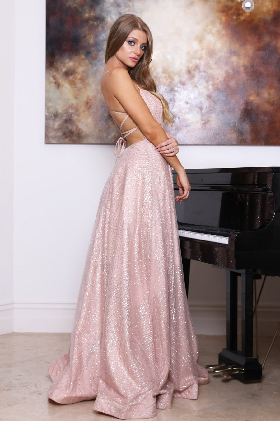 TINA HOLLY COUTURE T18262 rose pink glitter ball gown with strappy back design, standing by grand piano. Brisbane to Gold Coast.