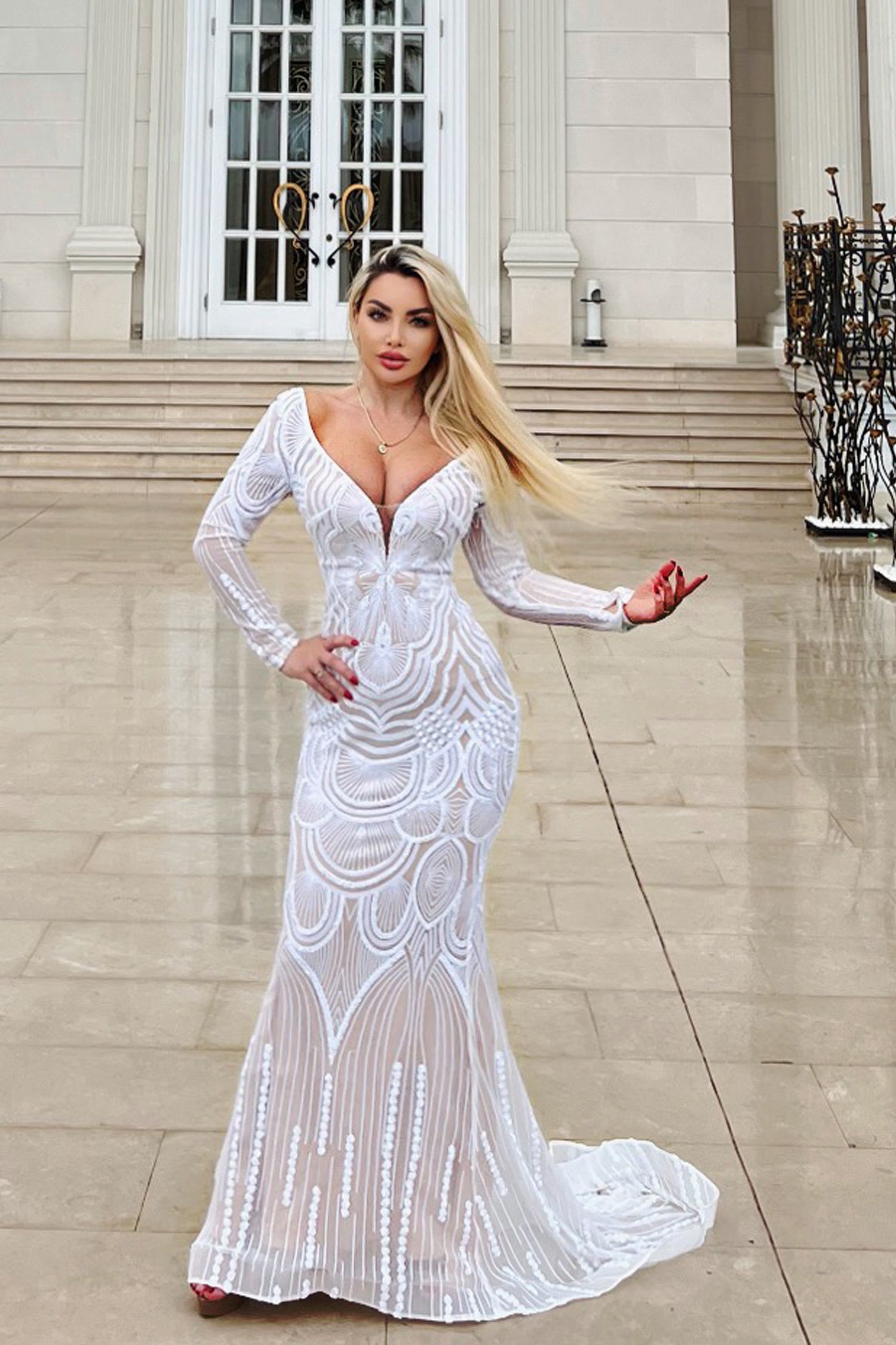 Glamorous long sleeve white lace mermaid gown with deep V-neckline, featuring intricate patterns. Elegant fit for formal occasions.