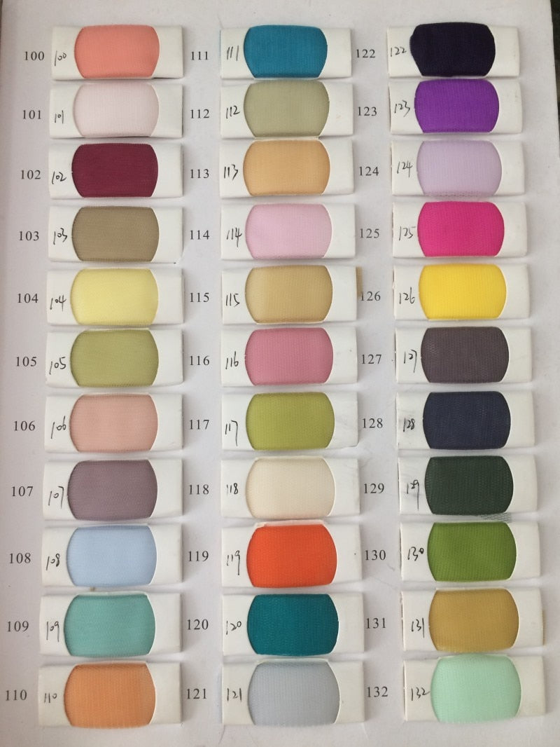 Fabric swatch card featuring various color samples marked with numbers from 100 to 132, showing a range of hues and tones.