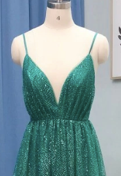 Elegant green sequin evening gown on mannequin highlighting deep neckline with adjustable straps, perfect for prom or formal events.