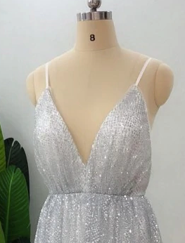 Elegant silver sequin gown on mannequin, featuring a deep V-neck and adjustable straps, ideal for formal occasions and prom.
