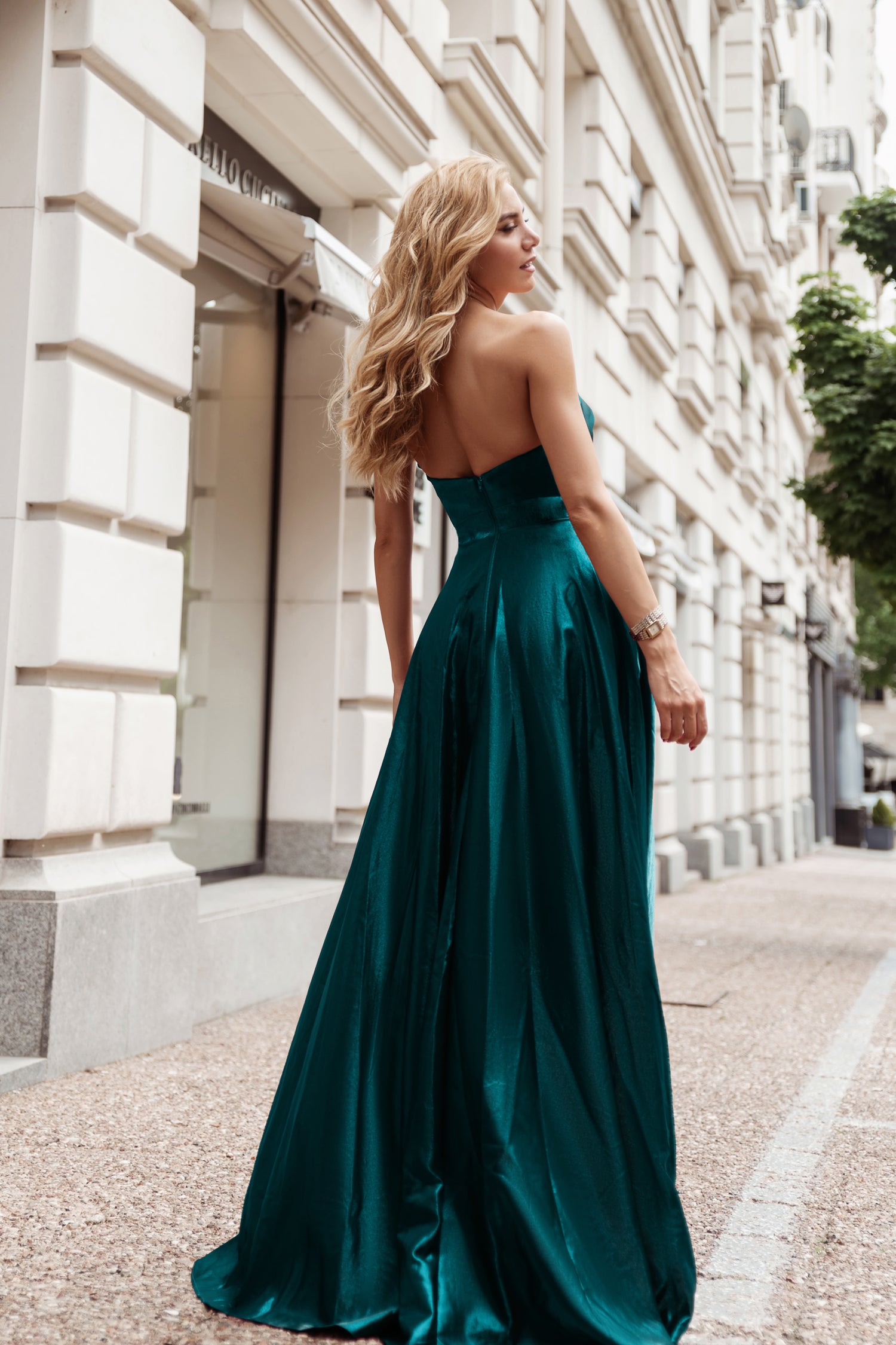 TE720 Peacock Emerald Green satin strapless formal dress with asymmetrical design, worn by woman walking city street. Brisbane to Gold Coast