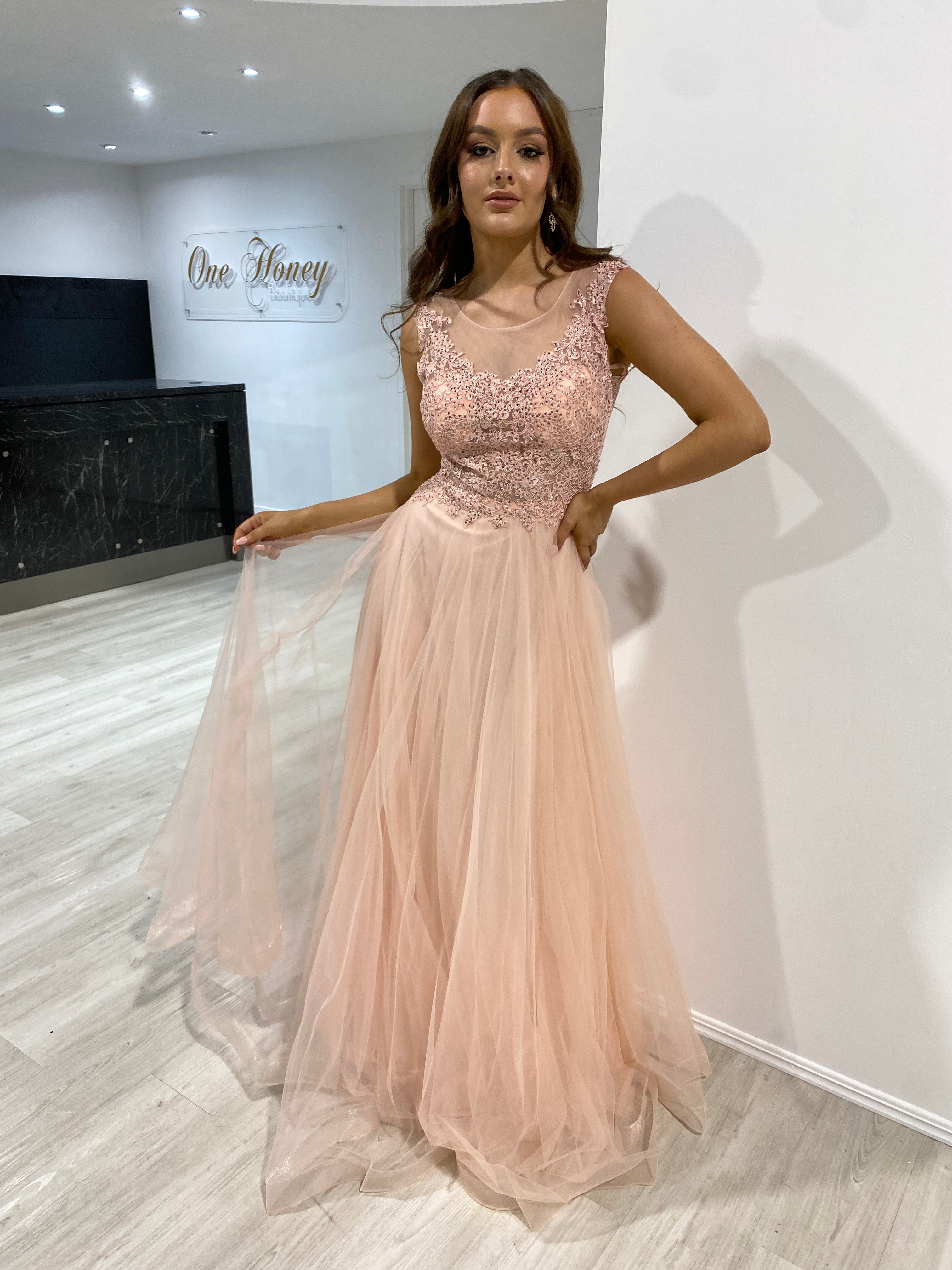 Woman wearing the Honey Couture MADDIE blush tulle lace bodice formal dress, designed by Australian designer, ideal for proms and evening events.