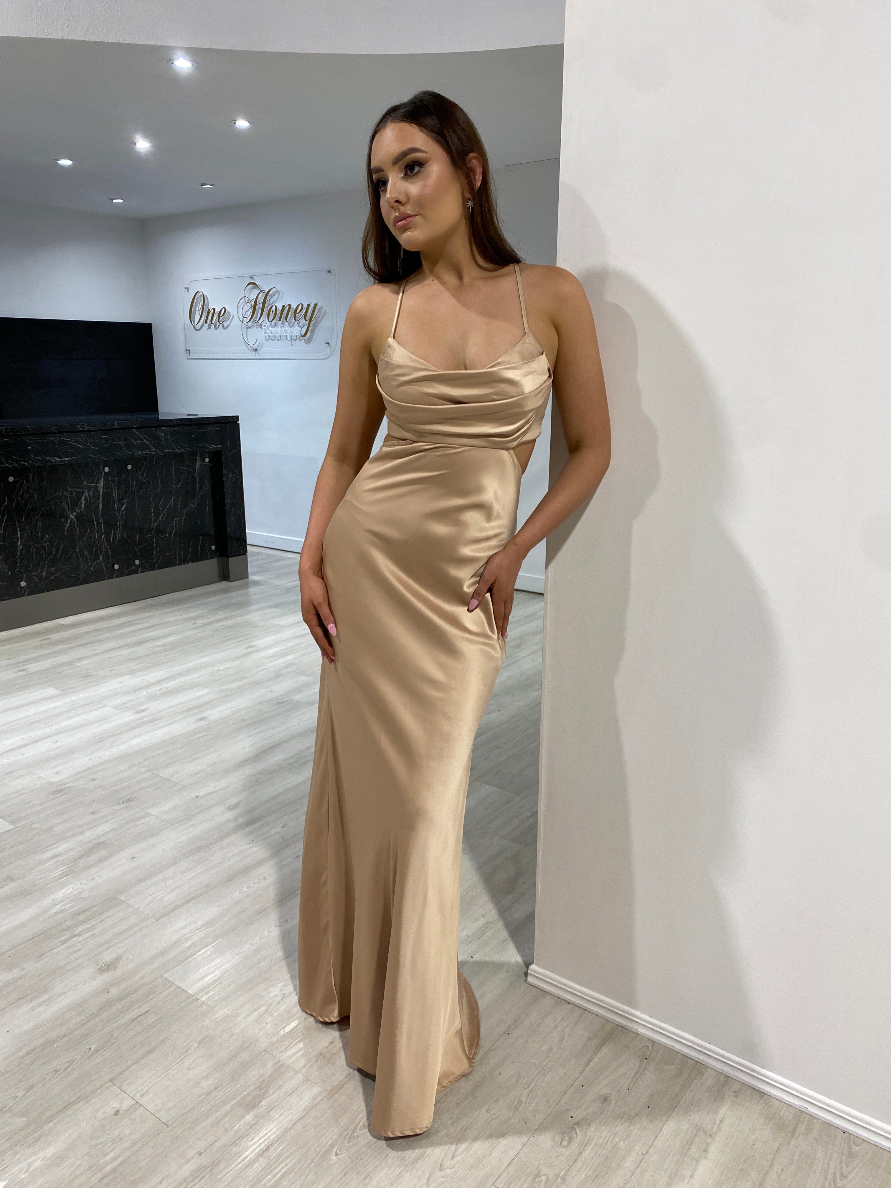 Model wearing Honey Couture ELLIE Gold Silky Cut Out Maxi Dress, an Australian Designer piece. Perfect for prom or evening. Affordable elegance.