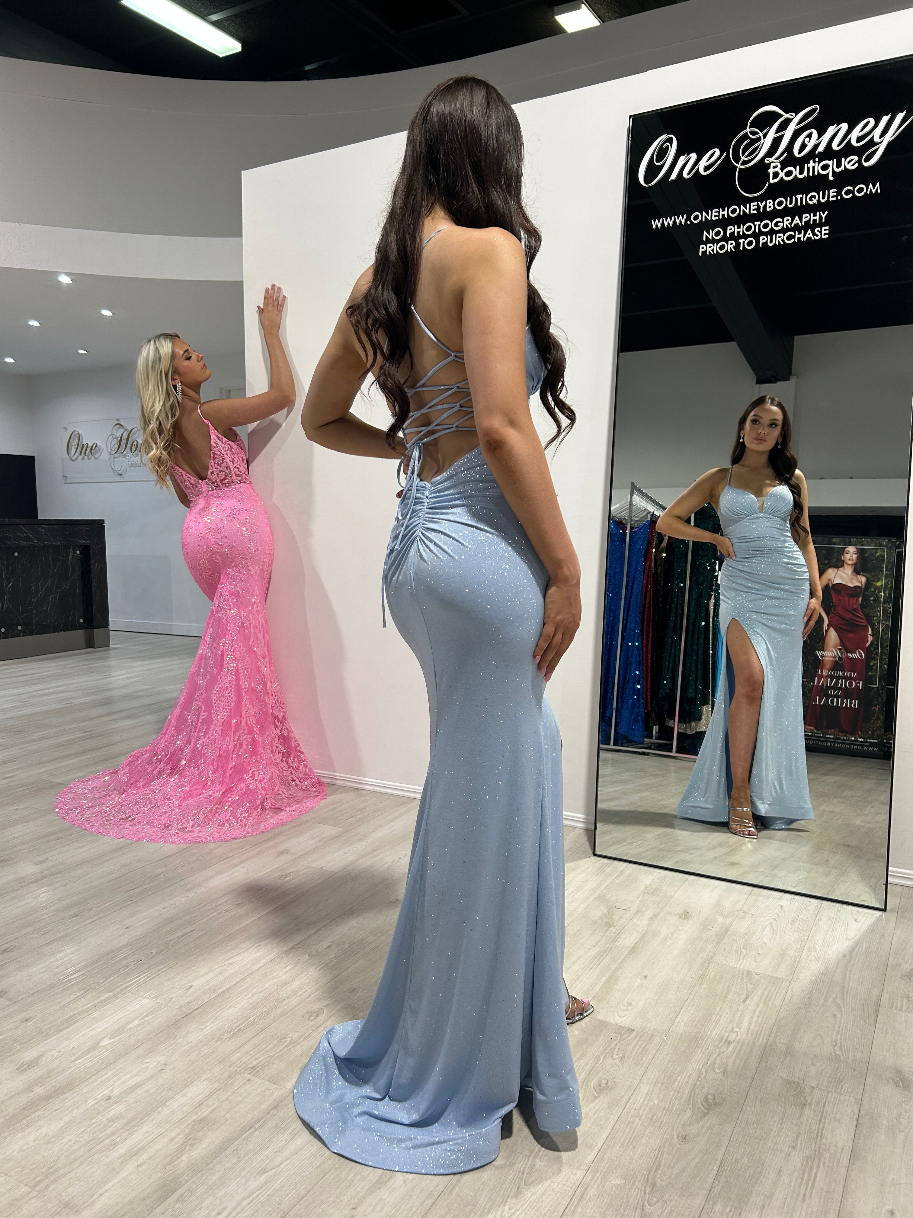 Woman in blue glitter mermaid gown with strappy open back and thigh-high slit, posing in boutique; reflection in mirror. Brisbane to Gold Coast.