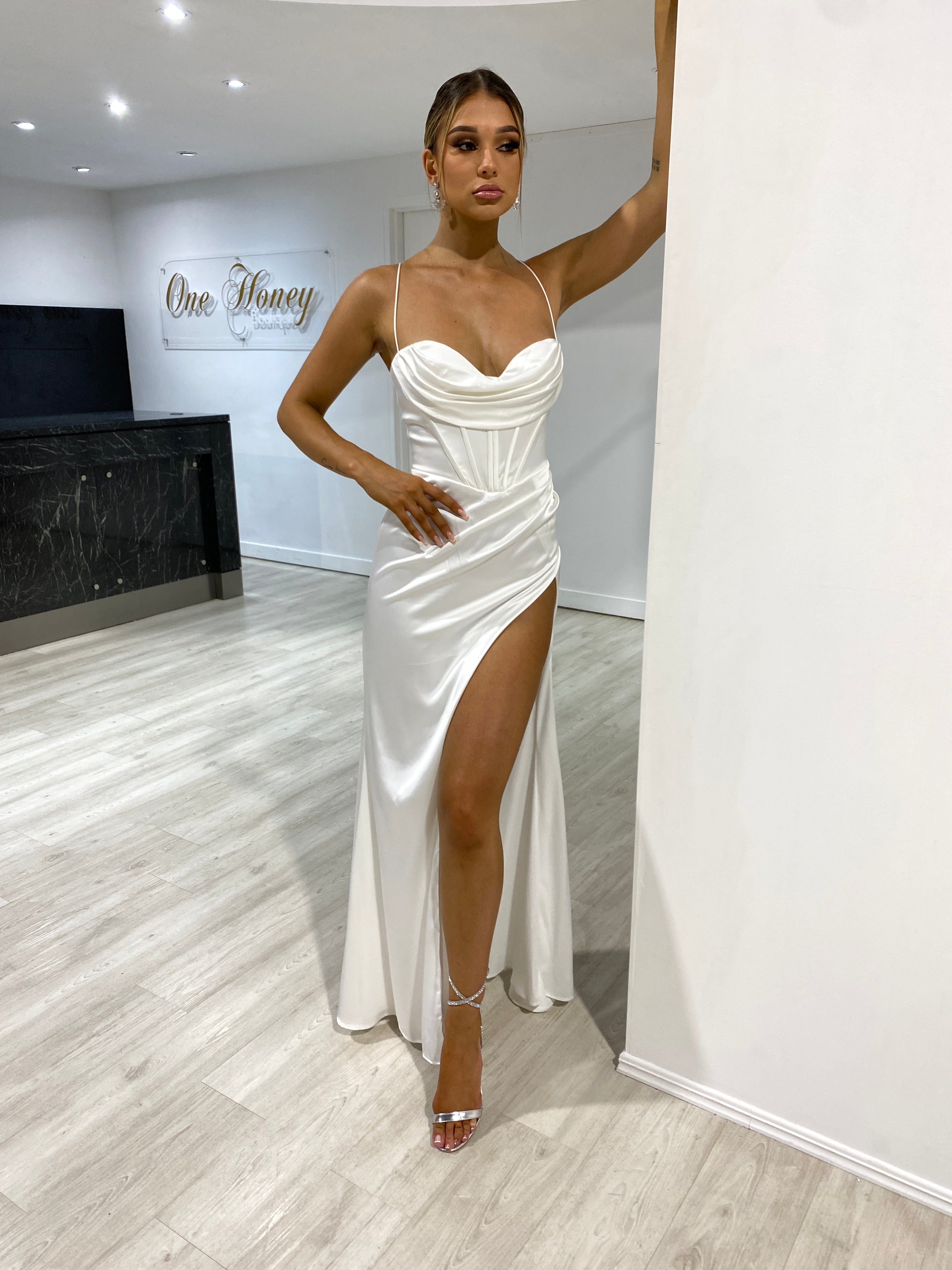 Model wearing Honey Couture ZENDAYA off white satin corset bustier dress with leg split, from Australian designer, ideal for prom or evening events.
