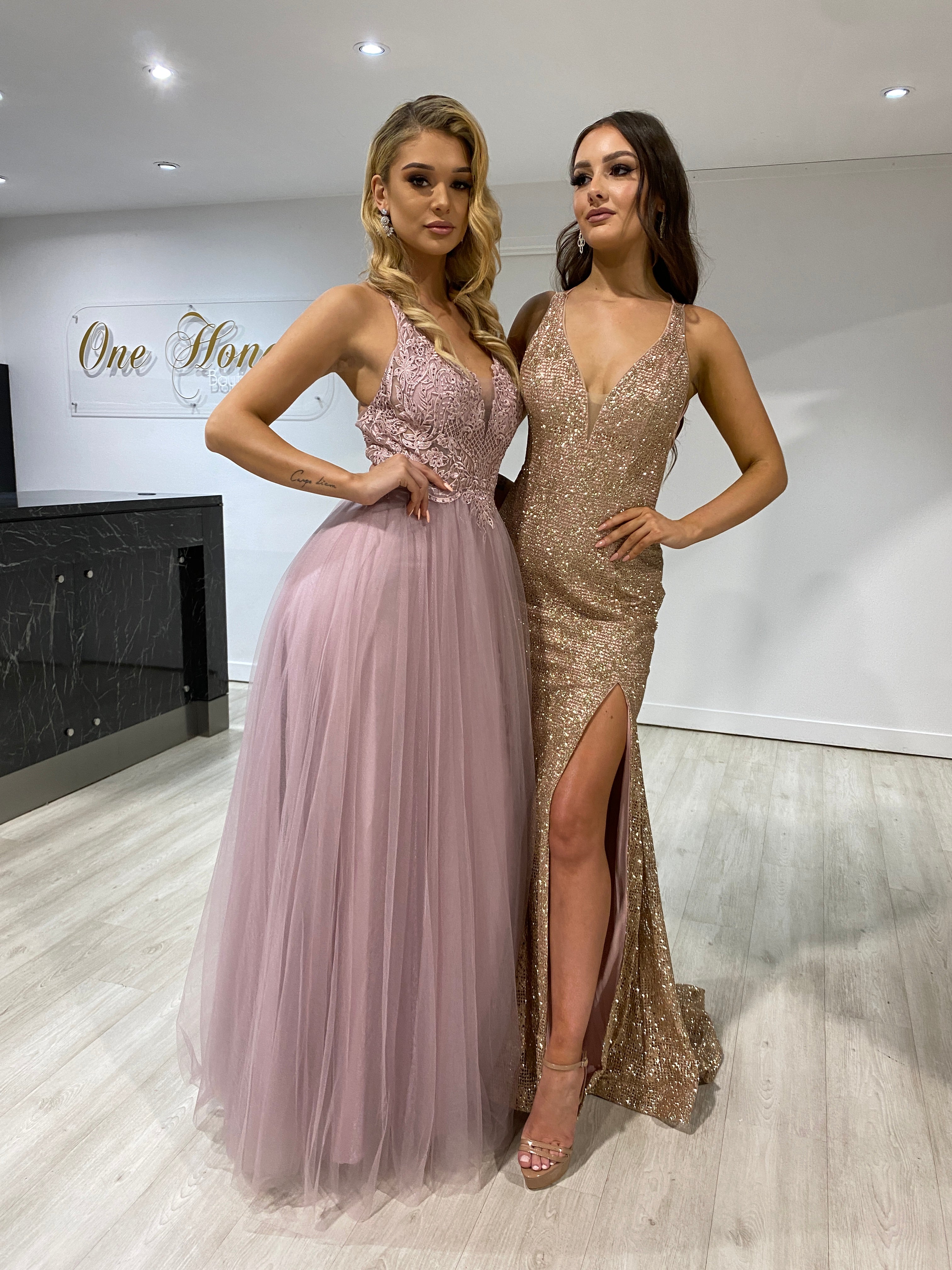 Two women in formal evening gowns; one in a blush pink tulle lace gown "INEZ" by Honey Couture, Australian Designer; perfect for proms.
