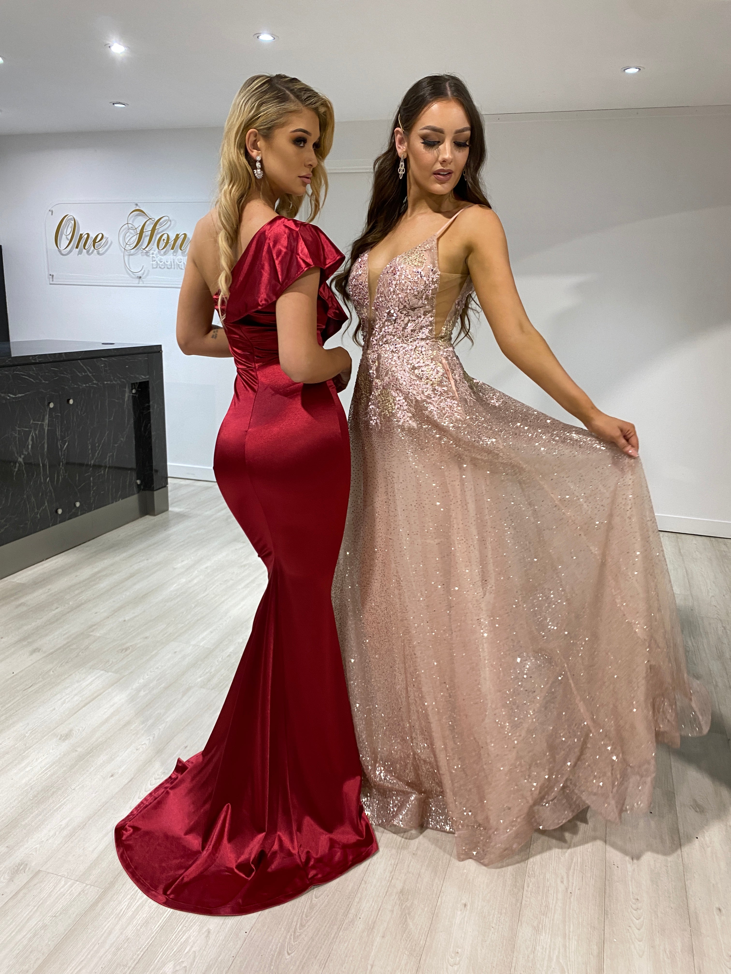 Two women in gowns, including Honey Couture's SIERRA Rose Gold & Pink Glitter Ballgown by Australian Designer, showcasing elegance and style.