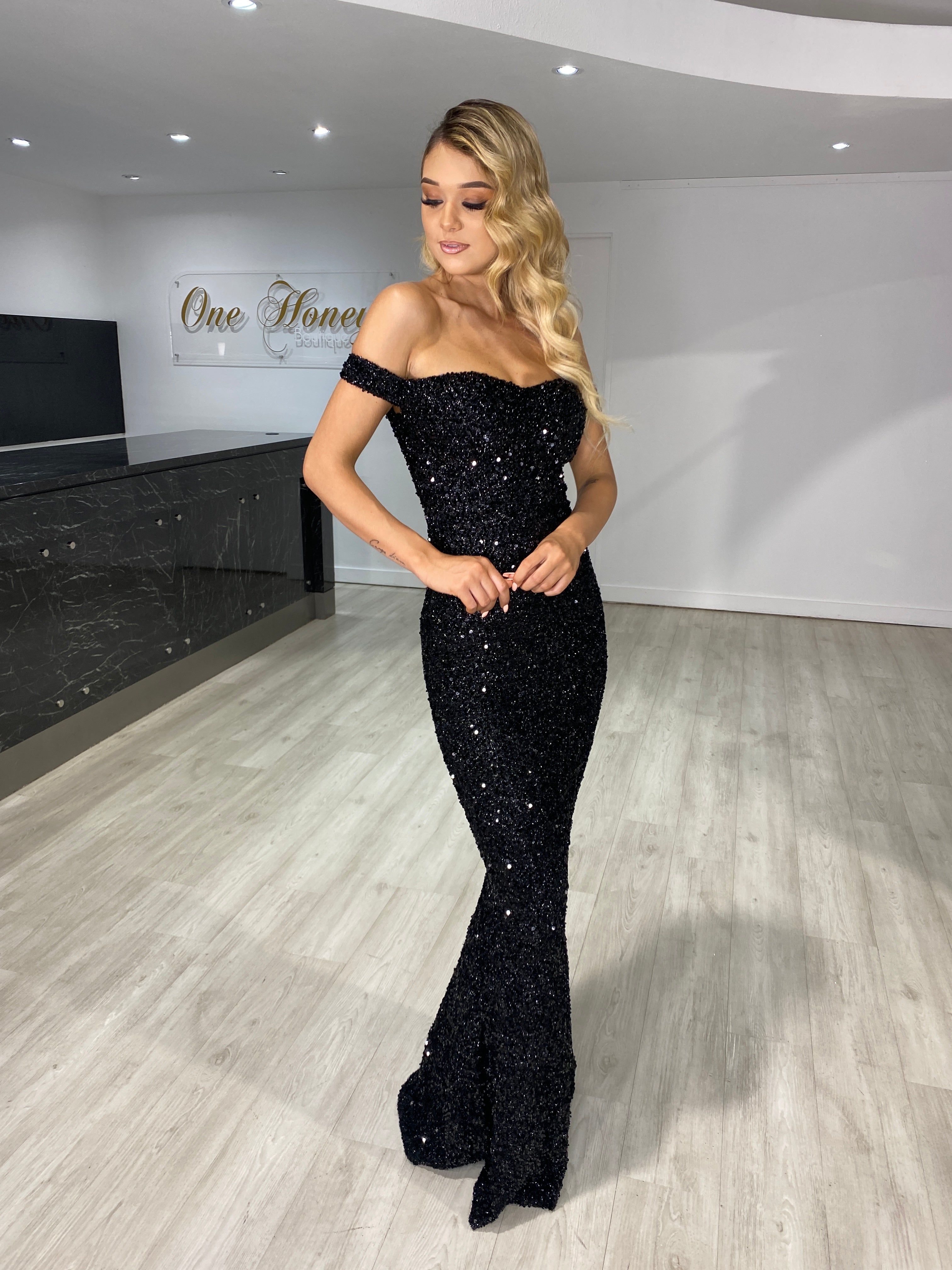 Woman wearing a Honey Couture BLAIR Black Sequin Off Shoulder Formal Gala Dress, elegant evening gown by Australian Designer, perfect for prom.