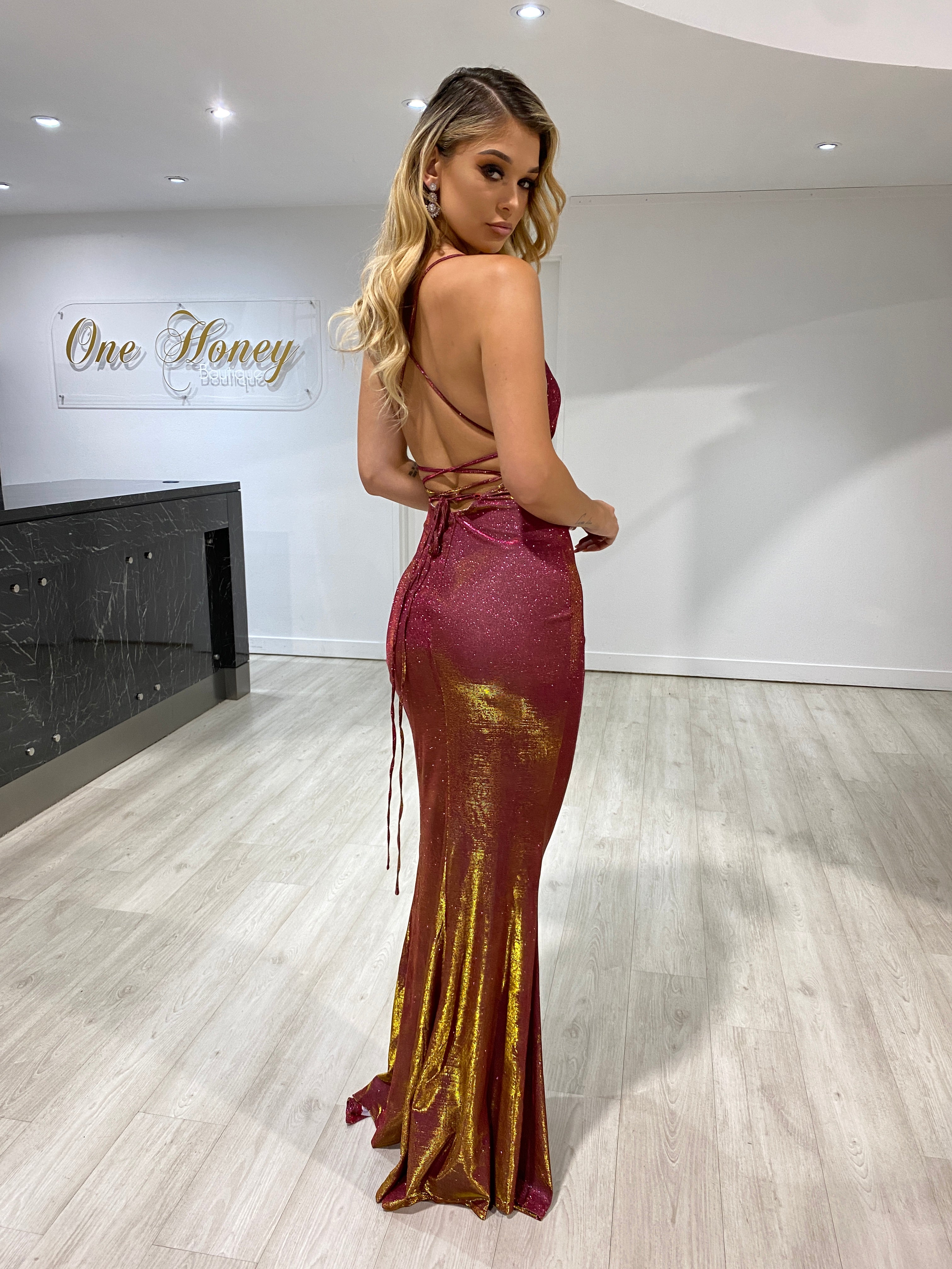Back view of a woman wearing a Honey Couture JENNIFER Burgundy Shimmer Lace Up Formal Dress by an Australian Designer, perfect for prom.
