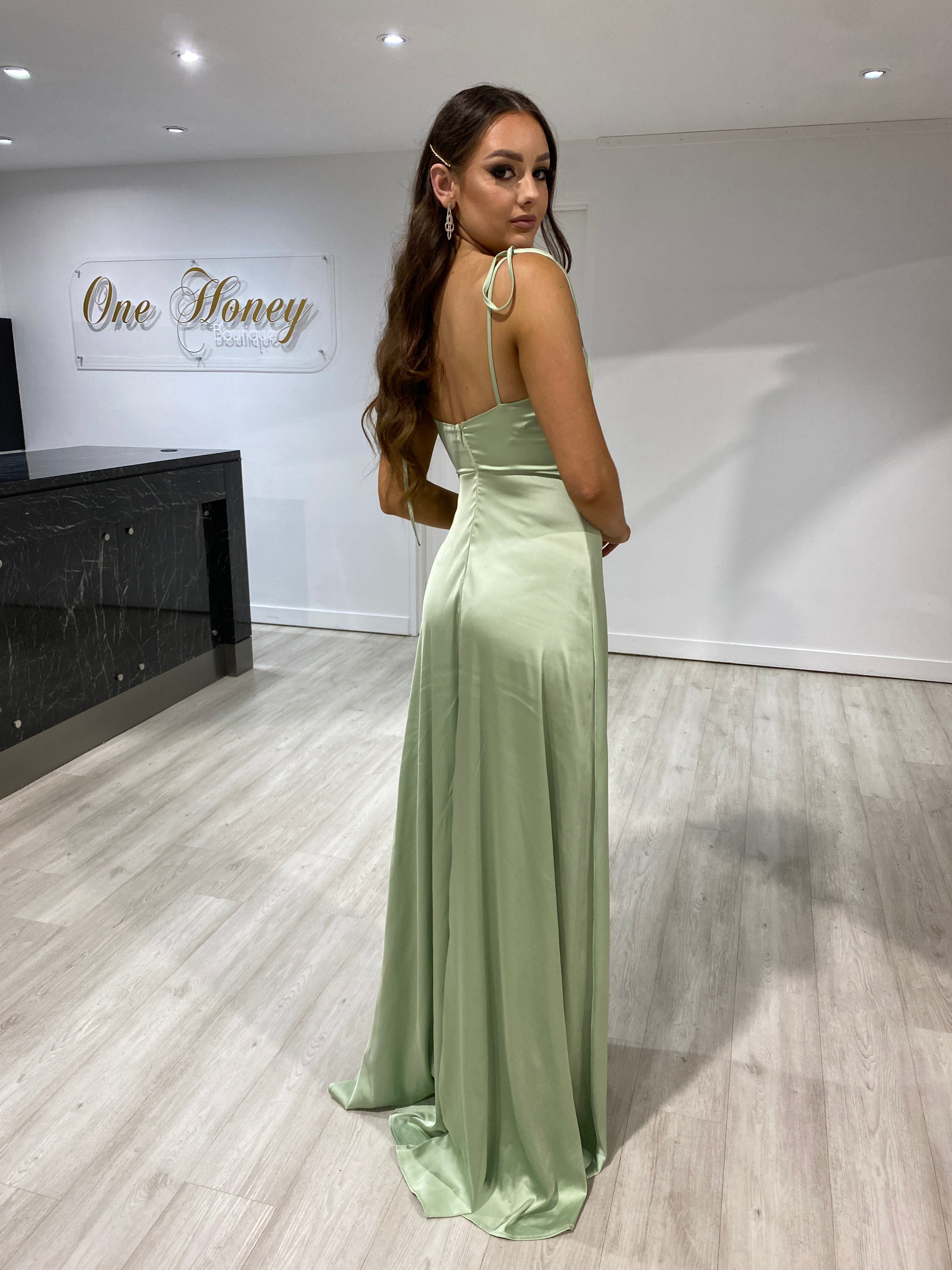 Woman wearing Honey Couture XENIA sage green formal bridesmaid dress with tie-up straps, designed by Australian designer for special occasions.