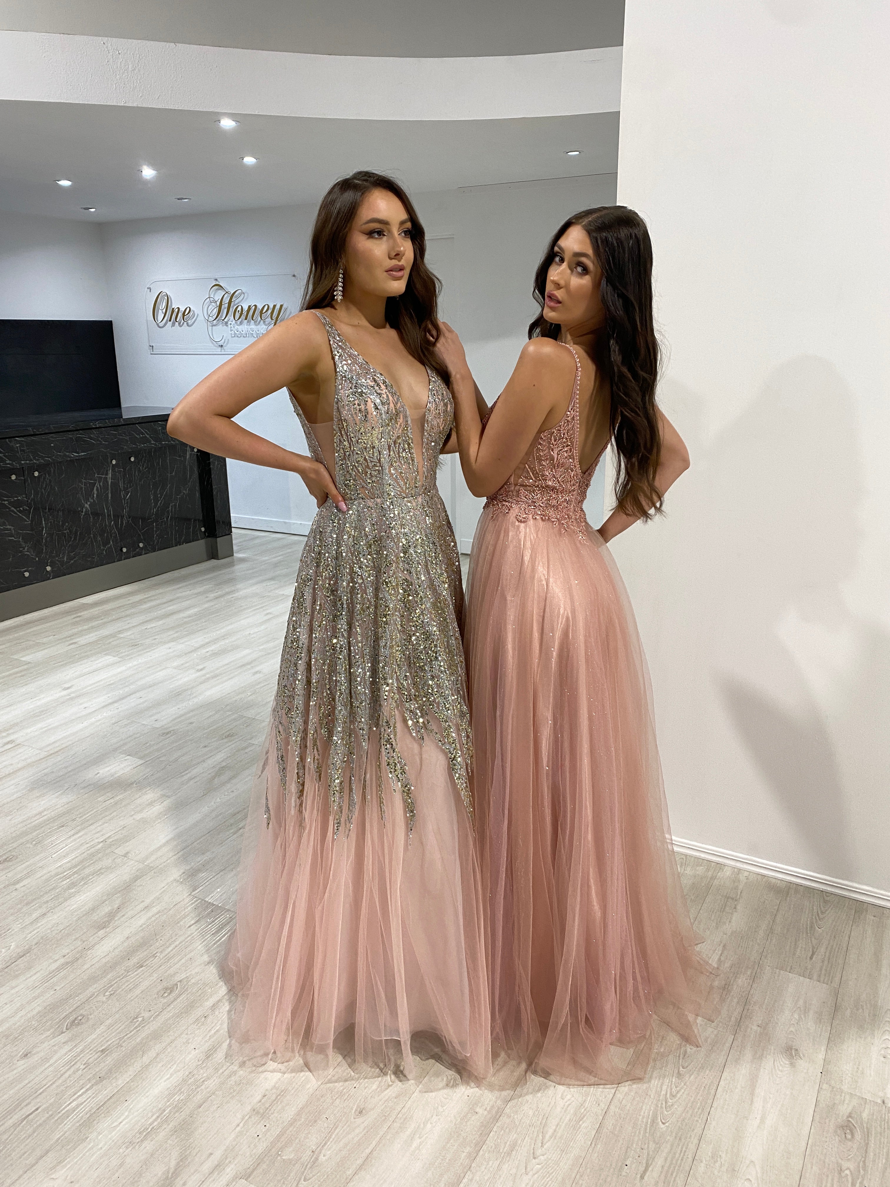Two women wearing elegant pink prom dresses with a beaded applique bodice and tulle skirt, standing indoors. Brisbane to Gold Coast, Australia.