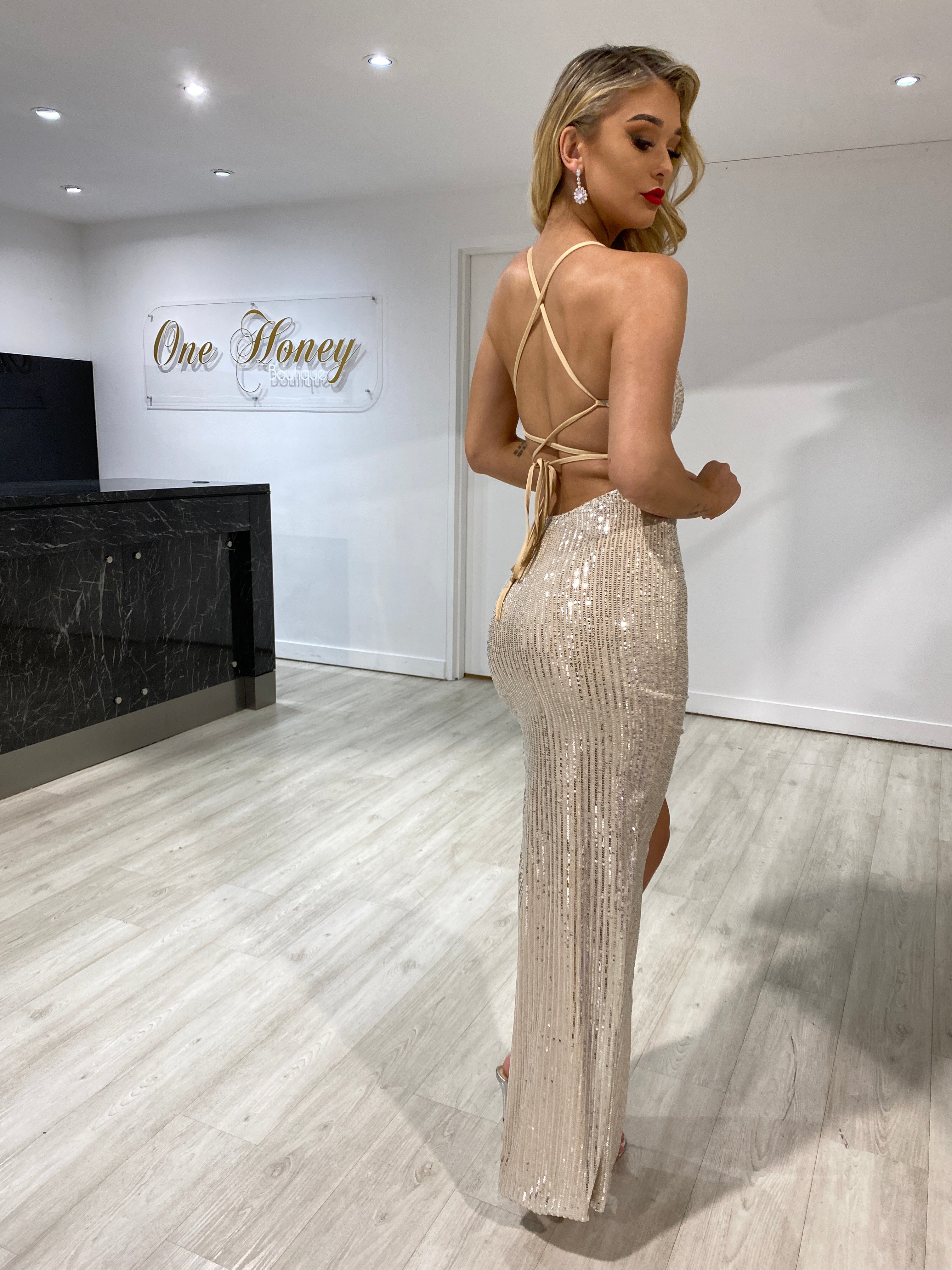 Model wearing Honey Couture LUZ Champagne Gold Lace Up Sequin Gown with leg split, from Australian Designer. Perfect for prom or evening wear.
