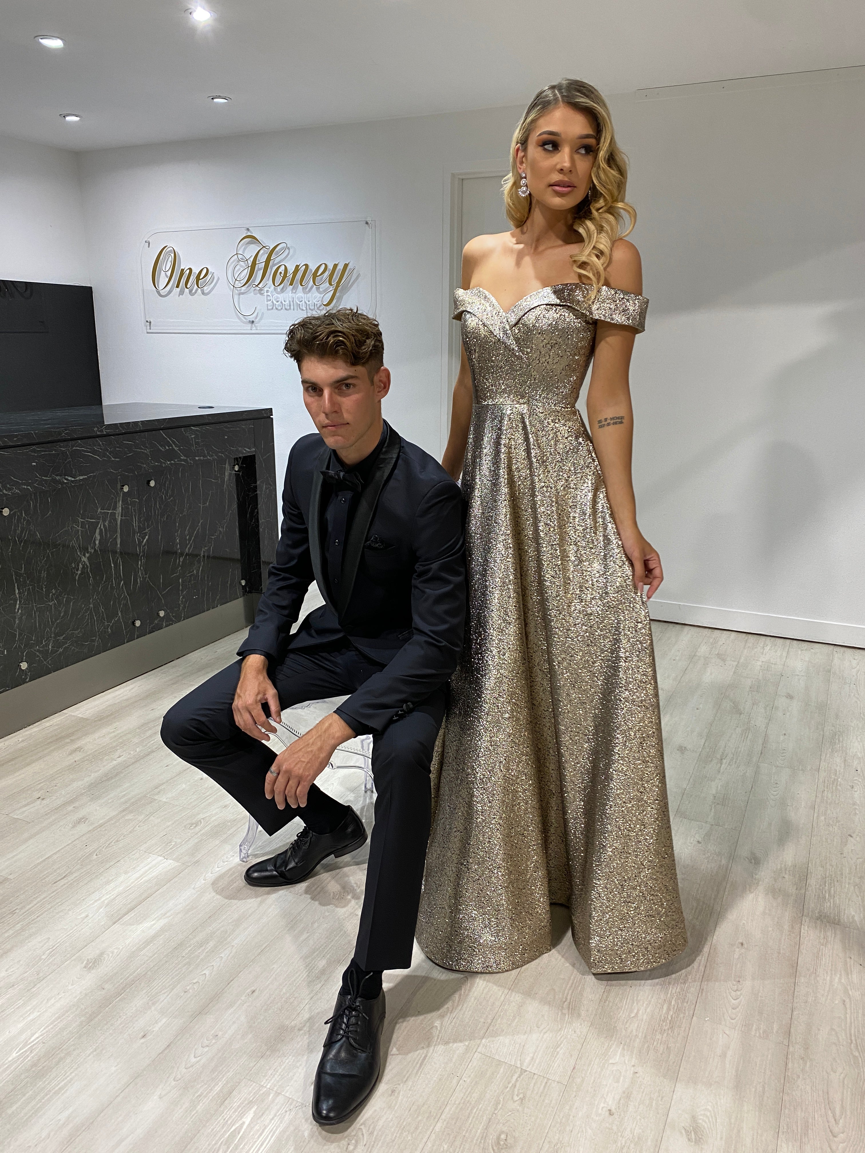 Model wearing Honey Couture DORA Bronze Metallic Shimmer Off Shoulder Formal Gown by Australian Designer, perfect for prom and evening events.