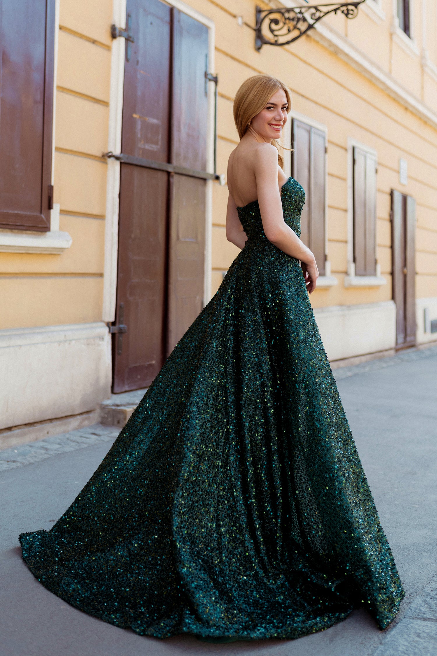Elegant green sequin evening gown with flowing train on urban street. Perfect for formal occasions in Brisbane to Gold Coast, Australia.